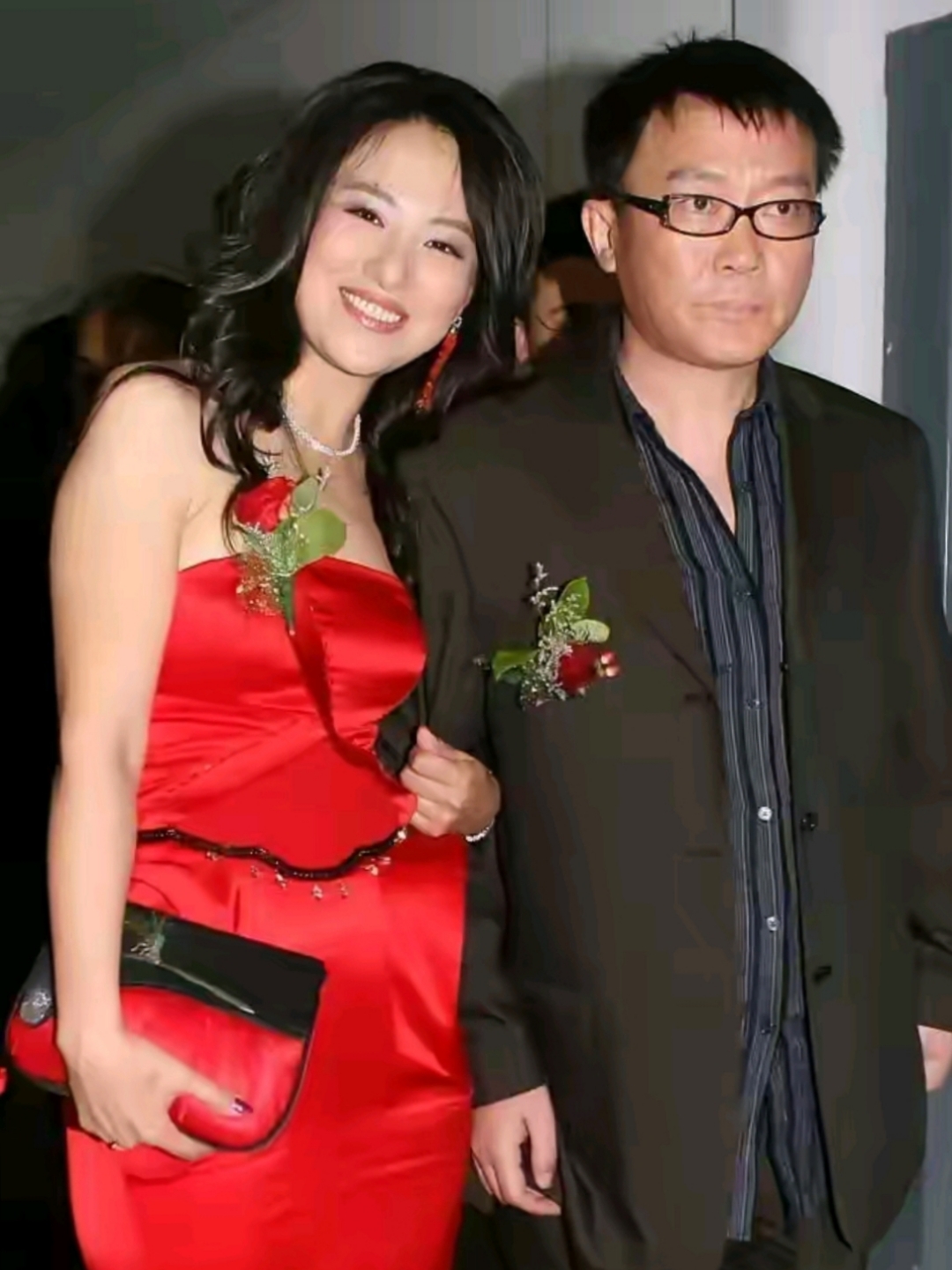 沈傲君偎依在老公旁笑靥如花.老公毫无表情.