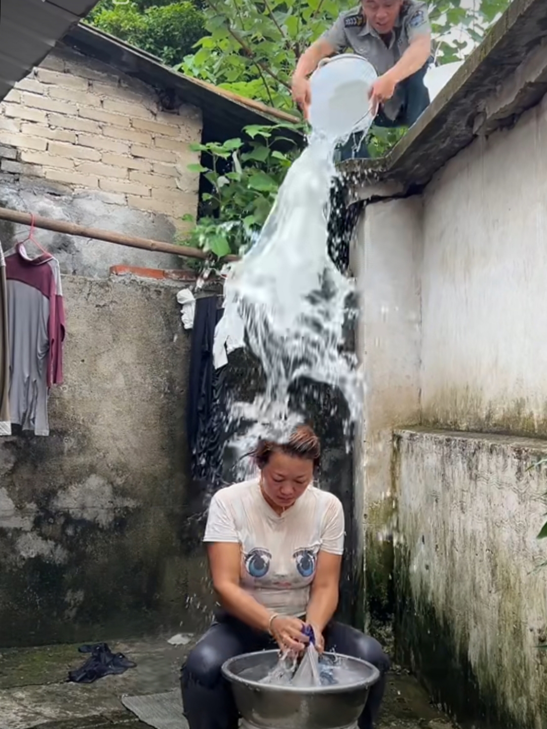 院子里,嫂子正专心洗衣服,却突遭小叔从房上泼下一桶水.