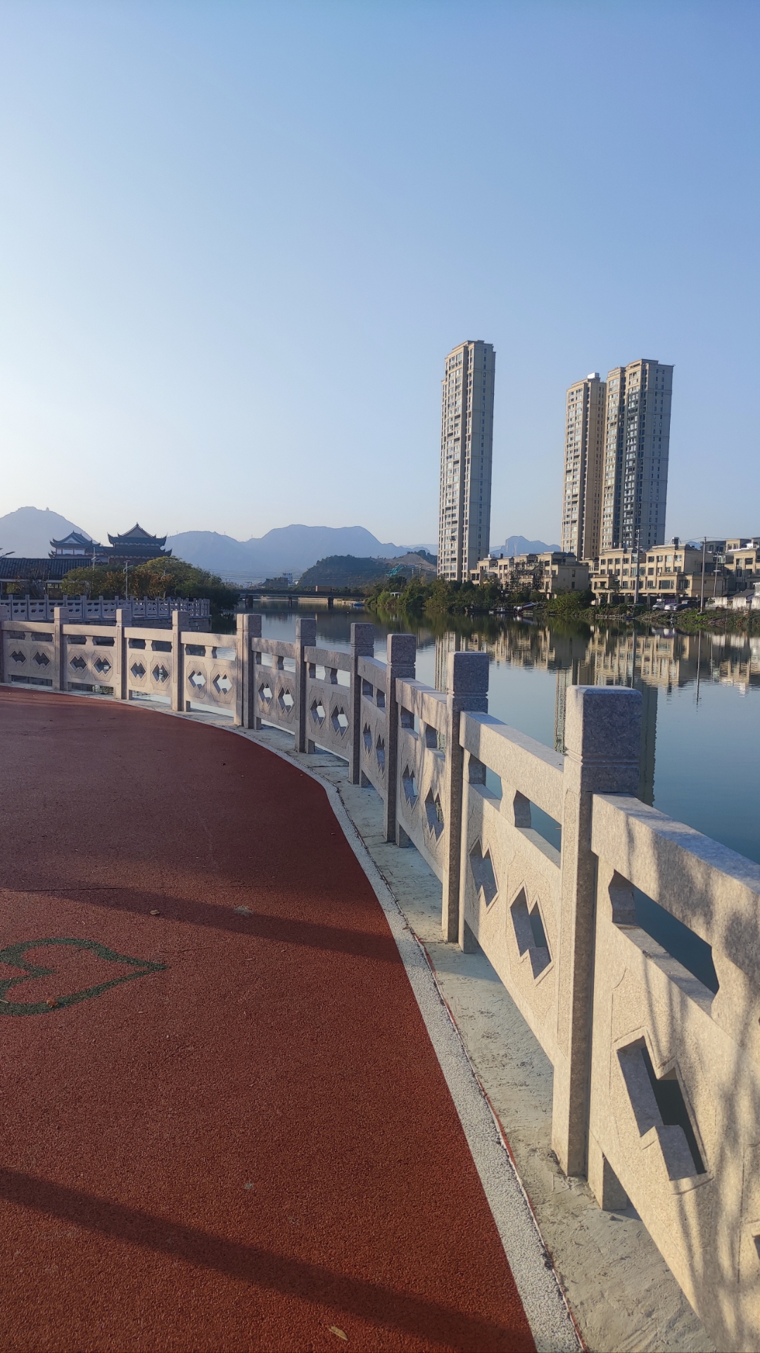 昨天下午沿着河边的红色跑道散步,远处是传统建筑和现