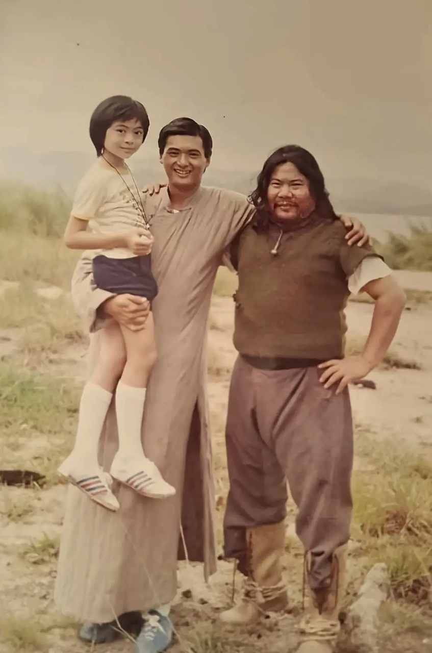 当年的周润发抱着童年樊少皇,周润发挽着的这个壮实汉子乃樊少皇的