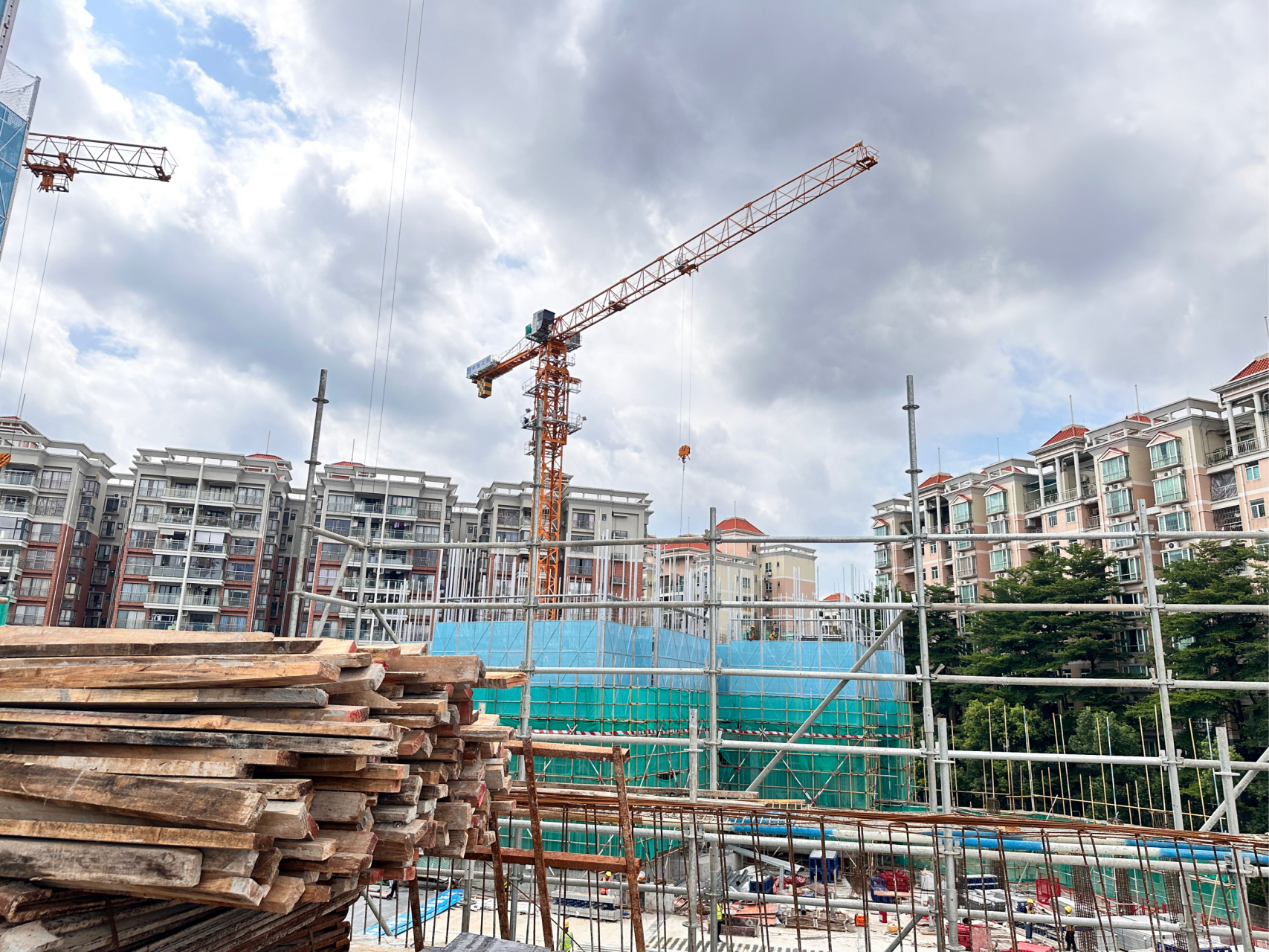 下的城市工地,灯火通明,远处高楼大厦灯光璀璨,近处是忙碌的施工场景