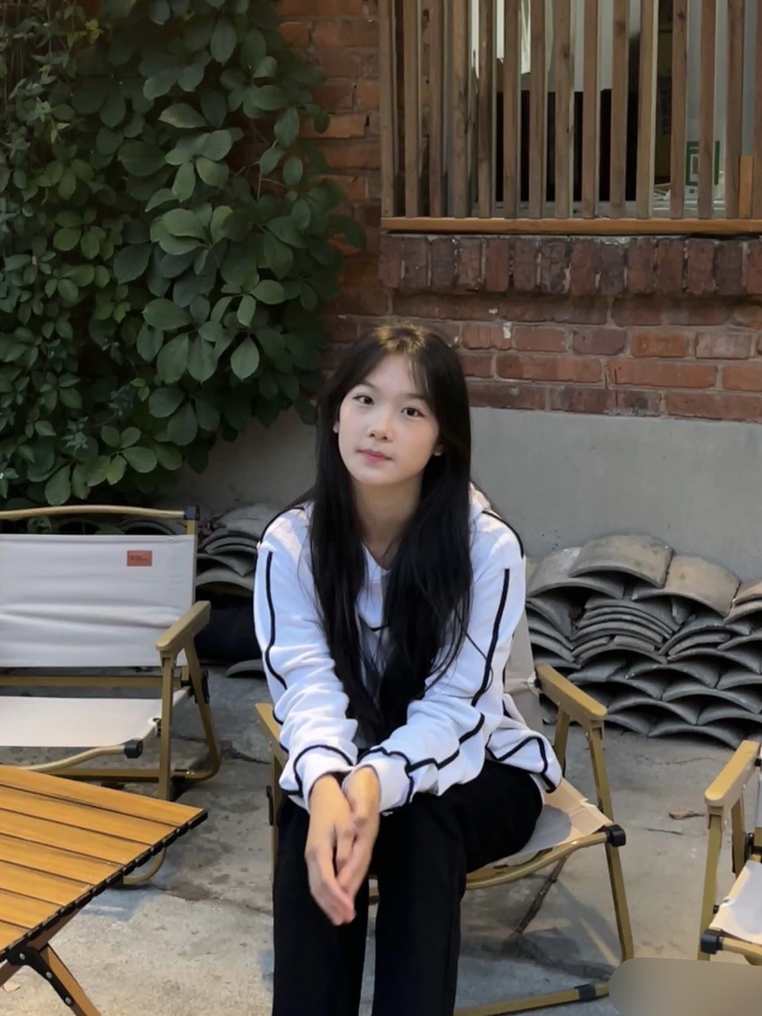 披肩长发随风轻扬,面带微笑,平静而友好