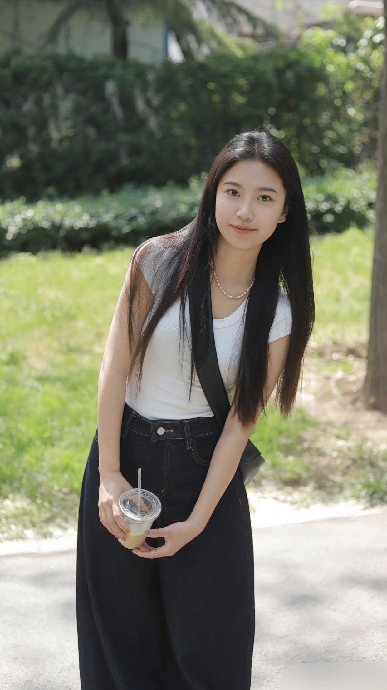 手中透明塑料杯,似乎装着清凉饮料,让人心生向往