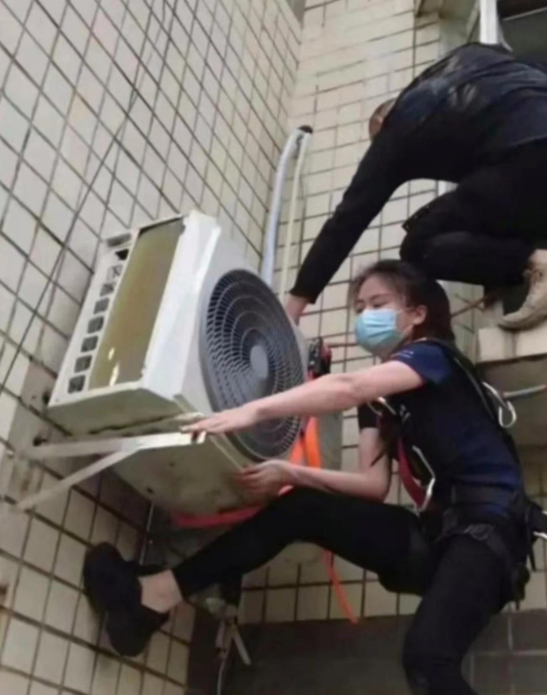 瞧这安装空调的大美女,她不仅美丽动人,更是技艺精湛,展现了新时代