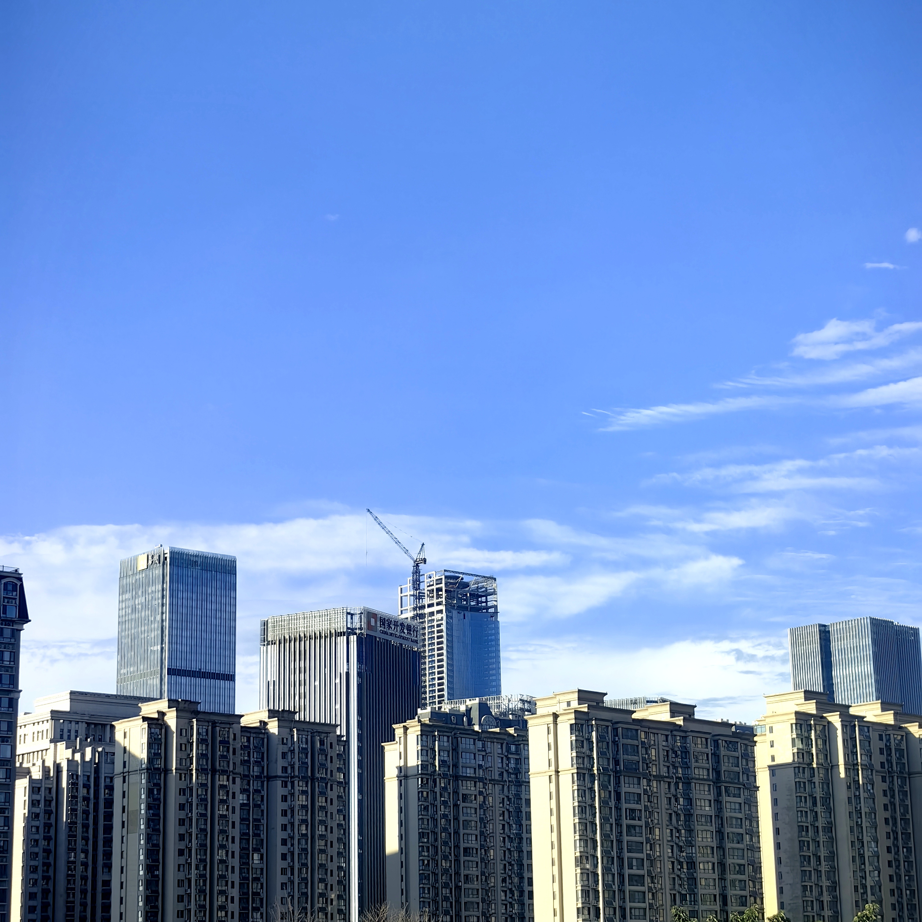 雨过天晴的济南,天蓝云白,城市如洗,空气中弥漫着湿润,阳光撒落在林立
