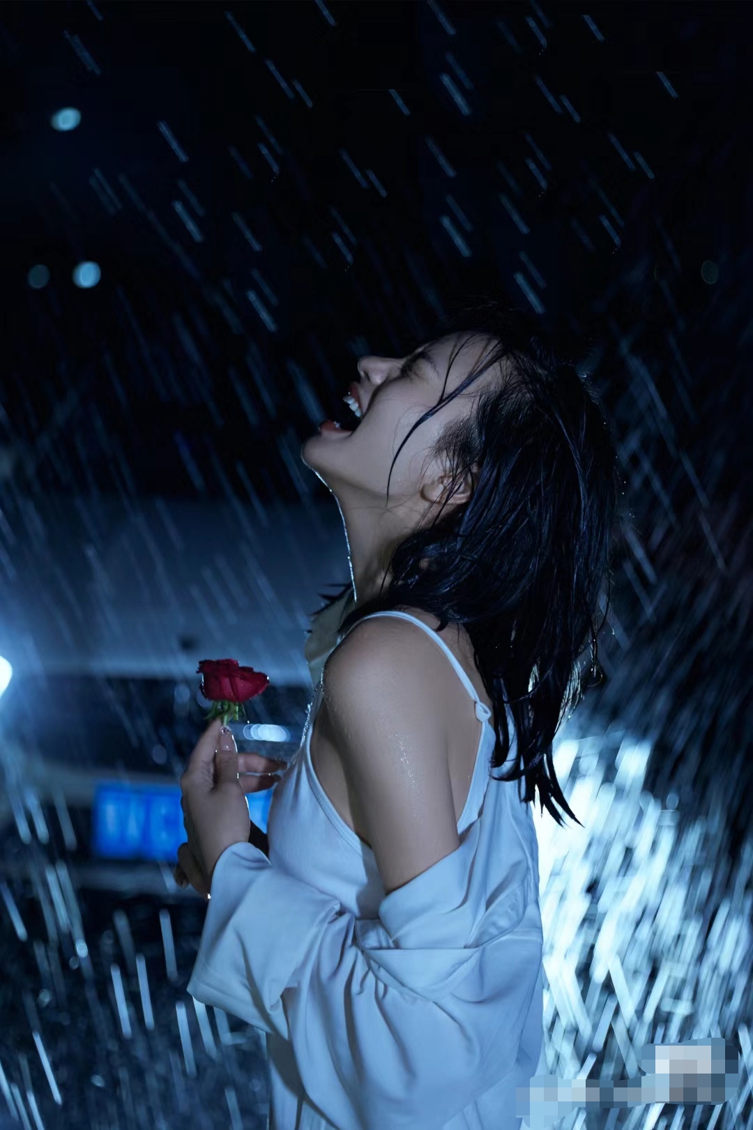夜晚的雨中漫步,她身着一件露肩上衣,手持一朵娇艳欲滴的红色玫瑰花