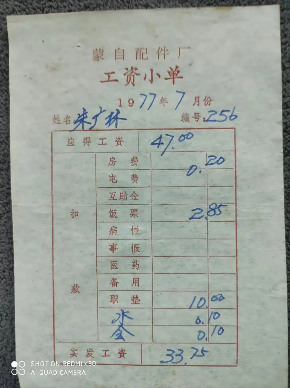这张照片拍摄的是1977年云南省蒙自市配件厂工人朱广林的工资单,应发