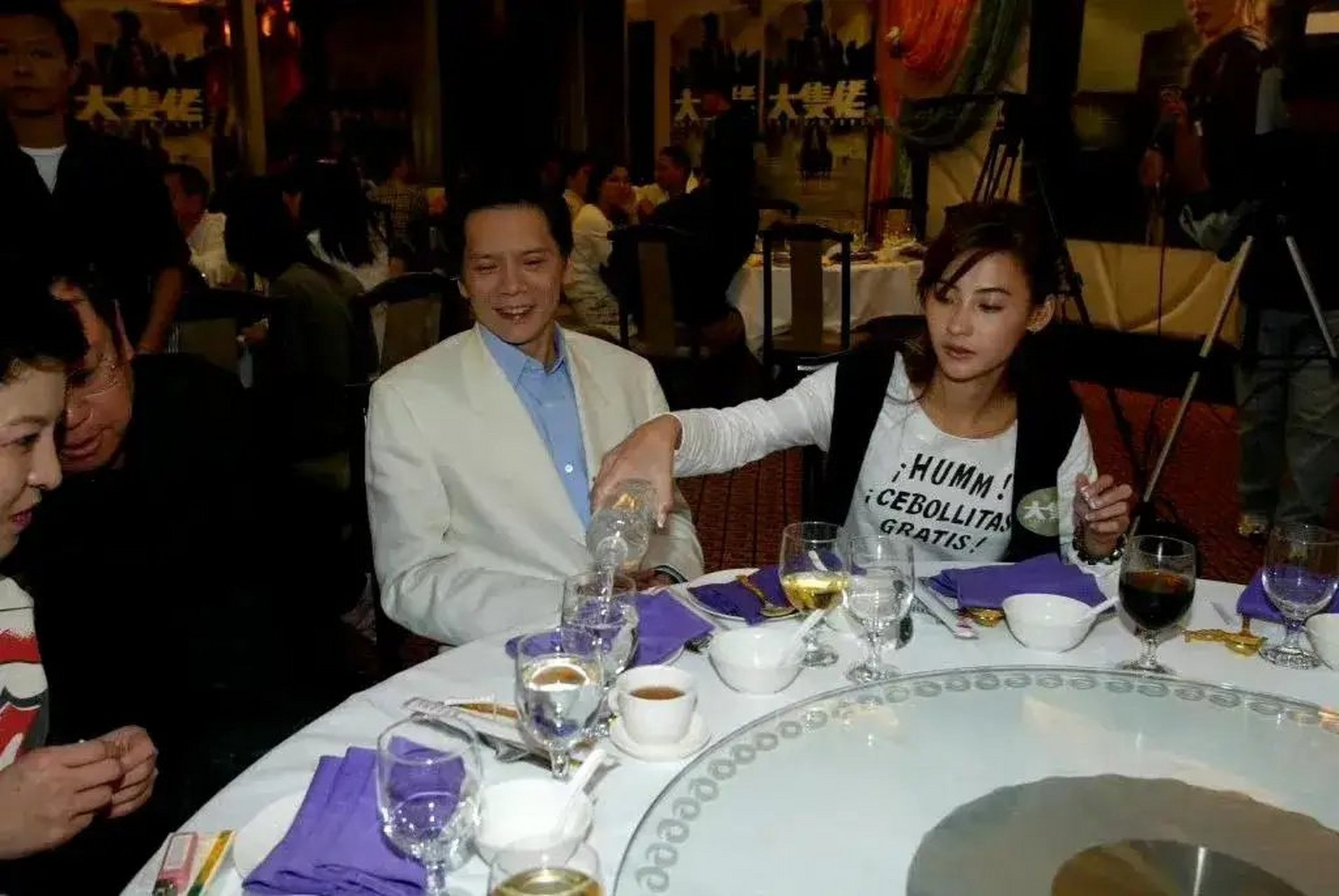 照片中的向华强双手擦兜,默默的看着张柏芝给自己倒酒,只是不