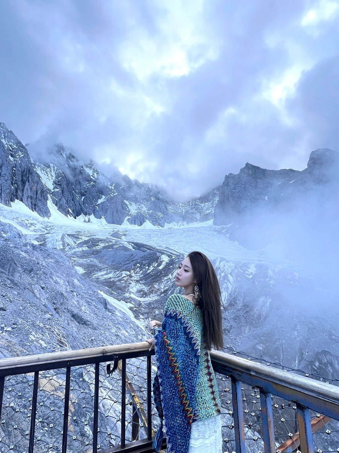 🏔️雪山之下,云雾之间,有一位优雅的女士,身着白色连衣裙,佩戴着