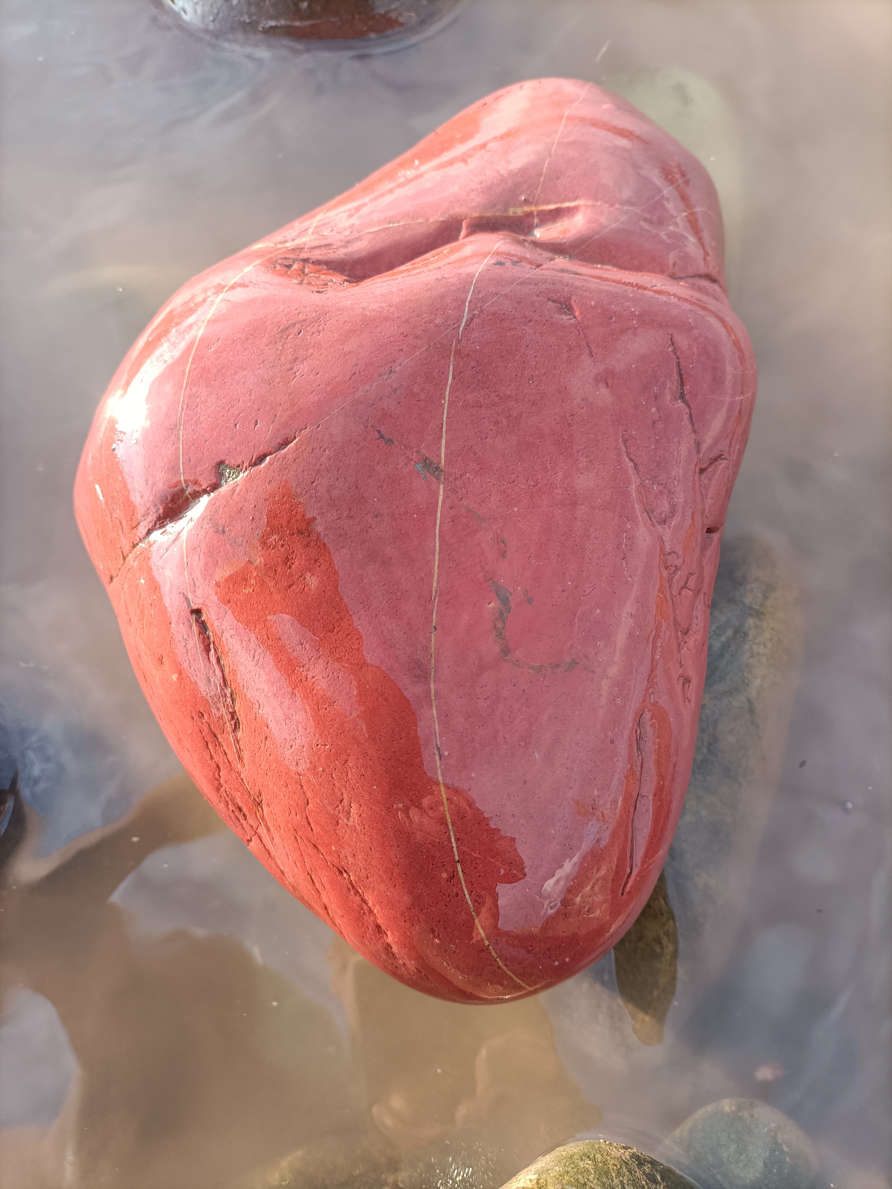 一块红色石头,侧面有丁点囹案,色泽艳丽