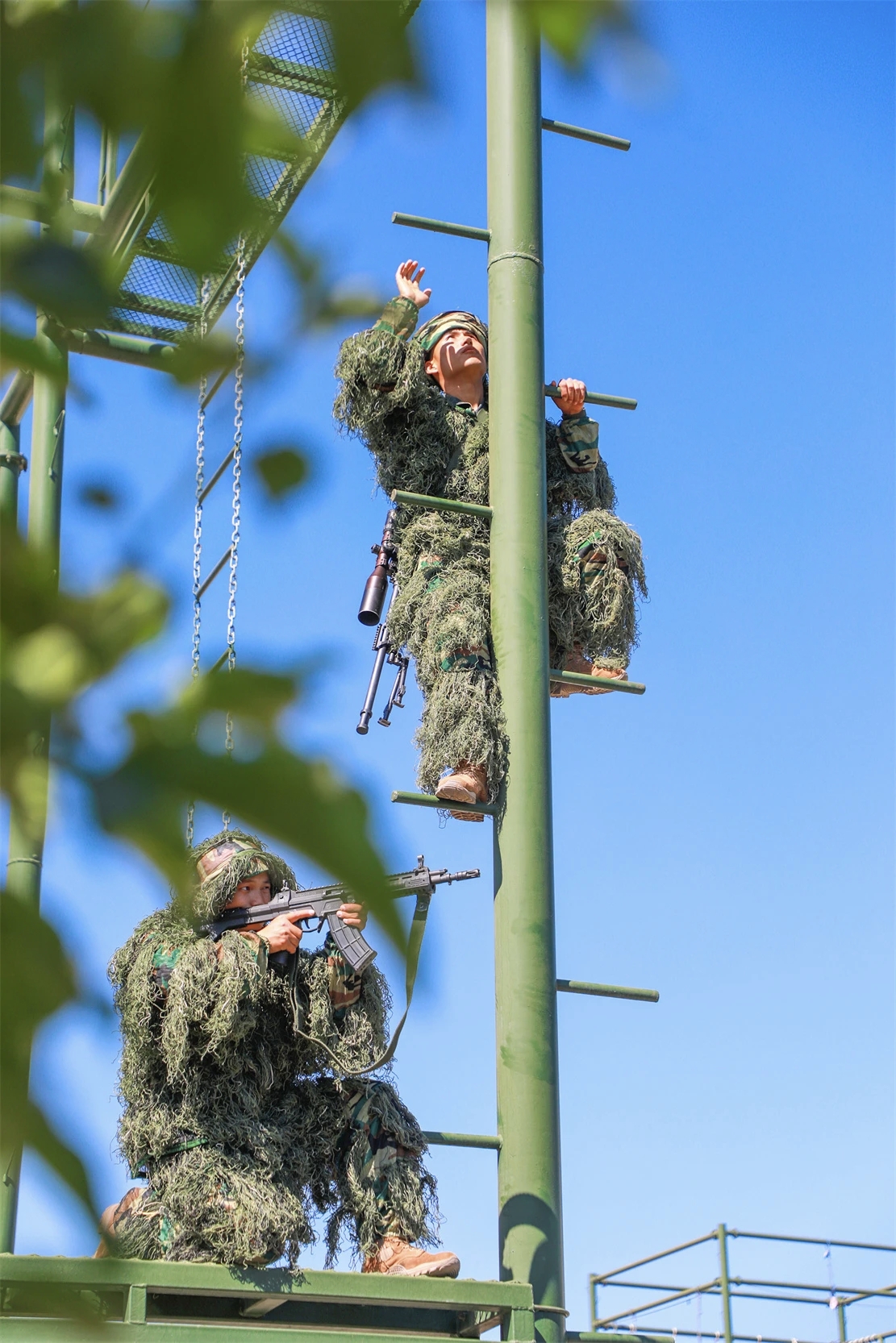 军营风采  蓝天如洗,绿树掩映间,两名身着吉利服的军人正在进行紧张