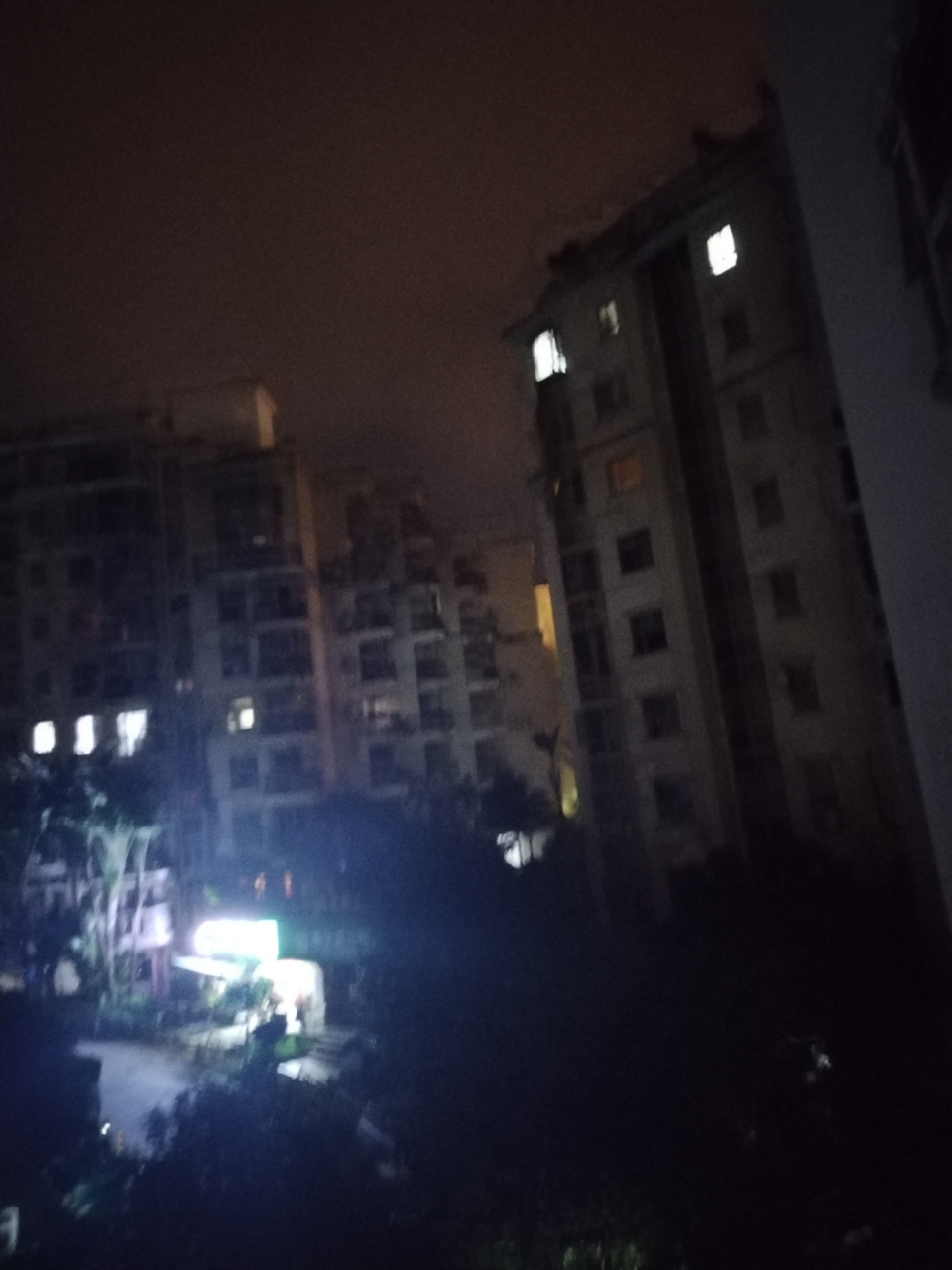 夜幕低垂,灯光闪烁91,几栋高层住宅楼静静地矗立,外墙的浅