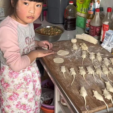 小妹妹正吃着热乎乎的饺子,脸上露出了满足的笑容.