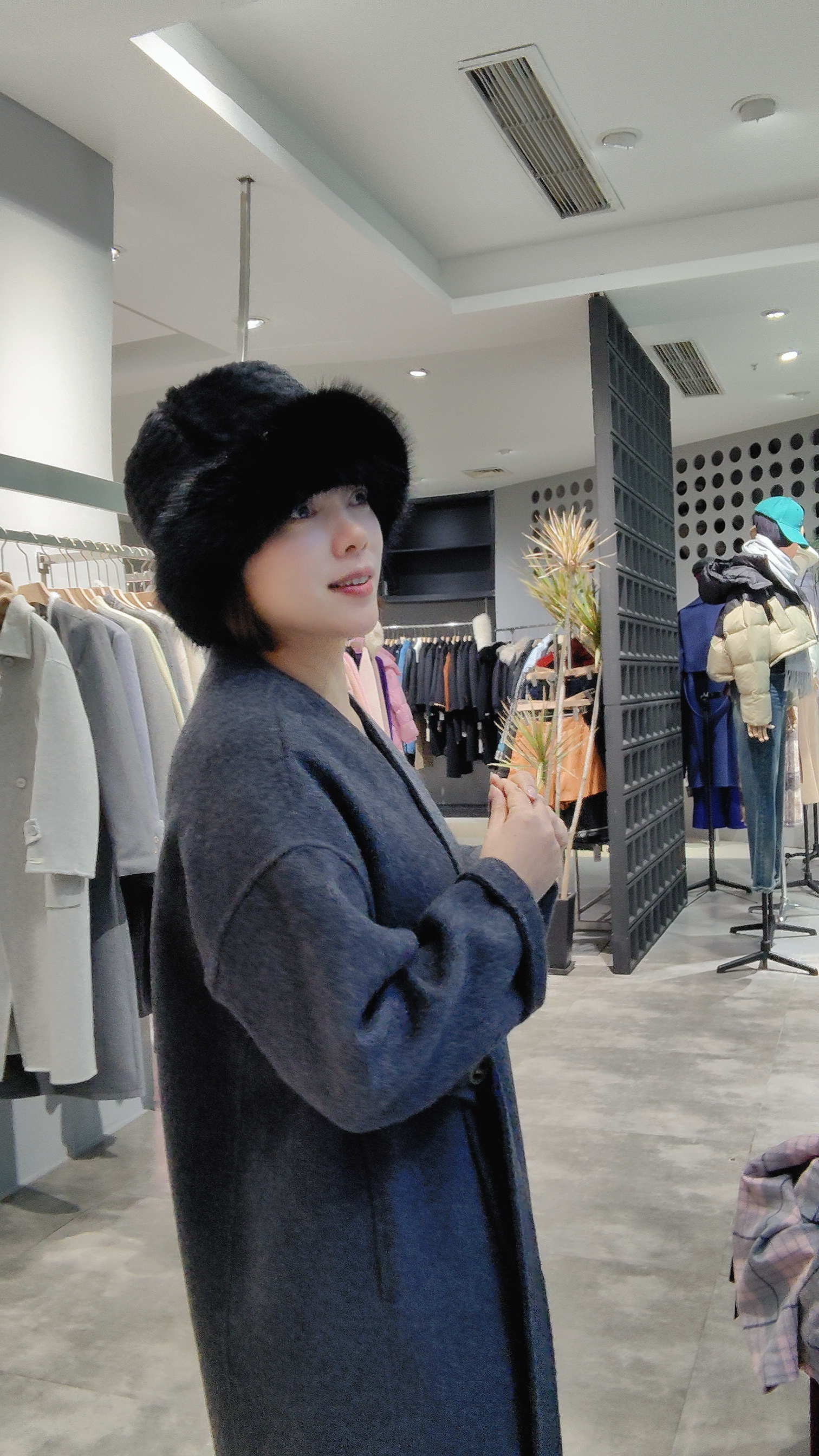 身后是一个服装店,里面展示了各种各样的衣服和配饰.