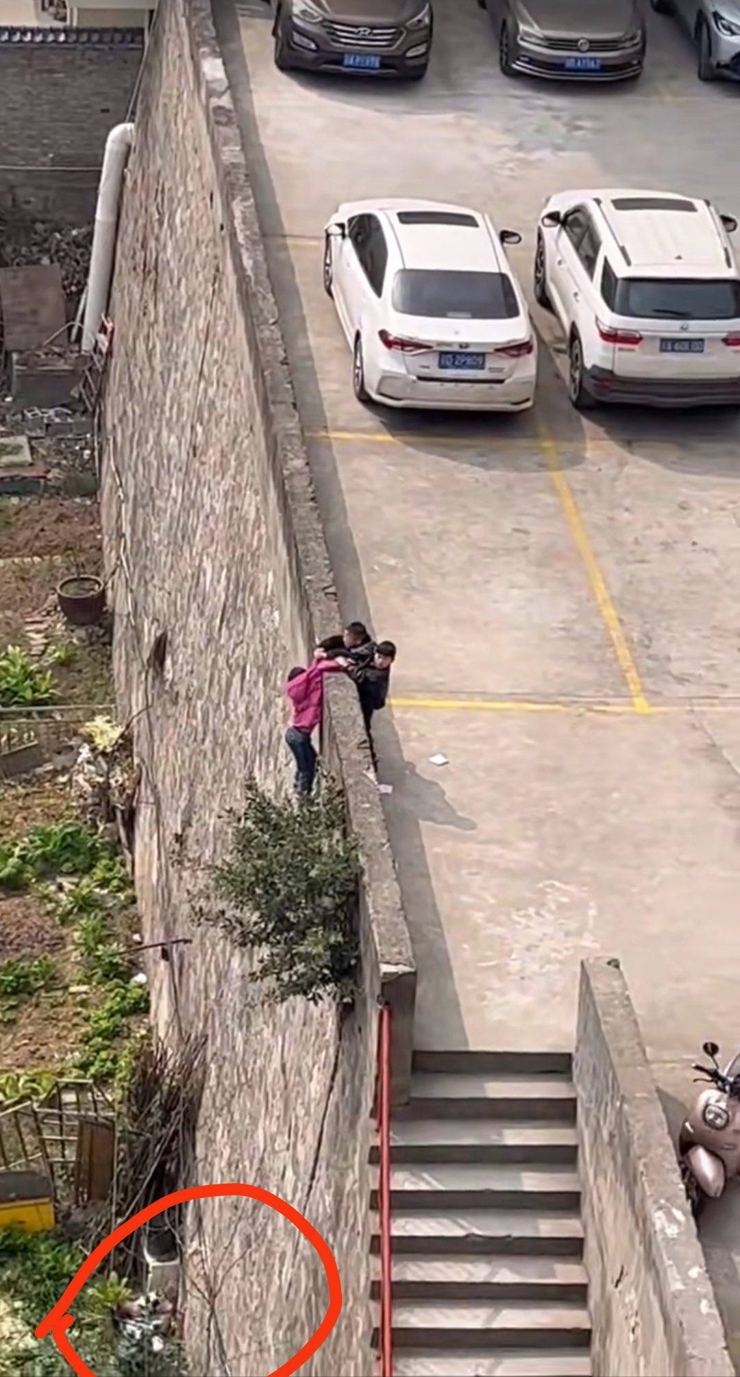 四个小孩在围墙边玩耍,其中一个小孩不慎跌落悬挂在围墙外,于是另外三