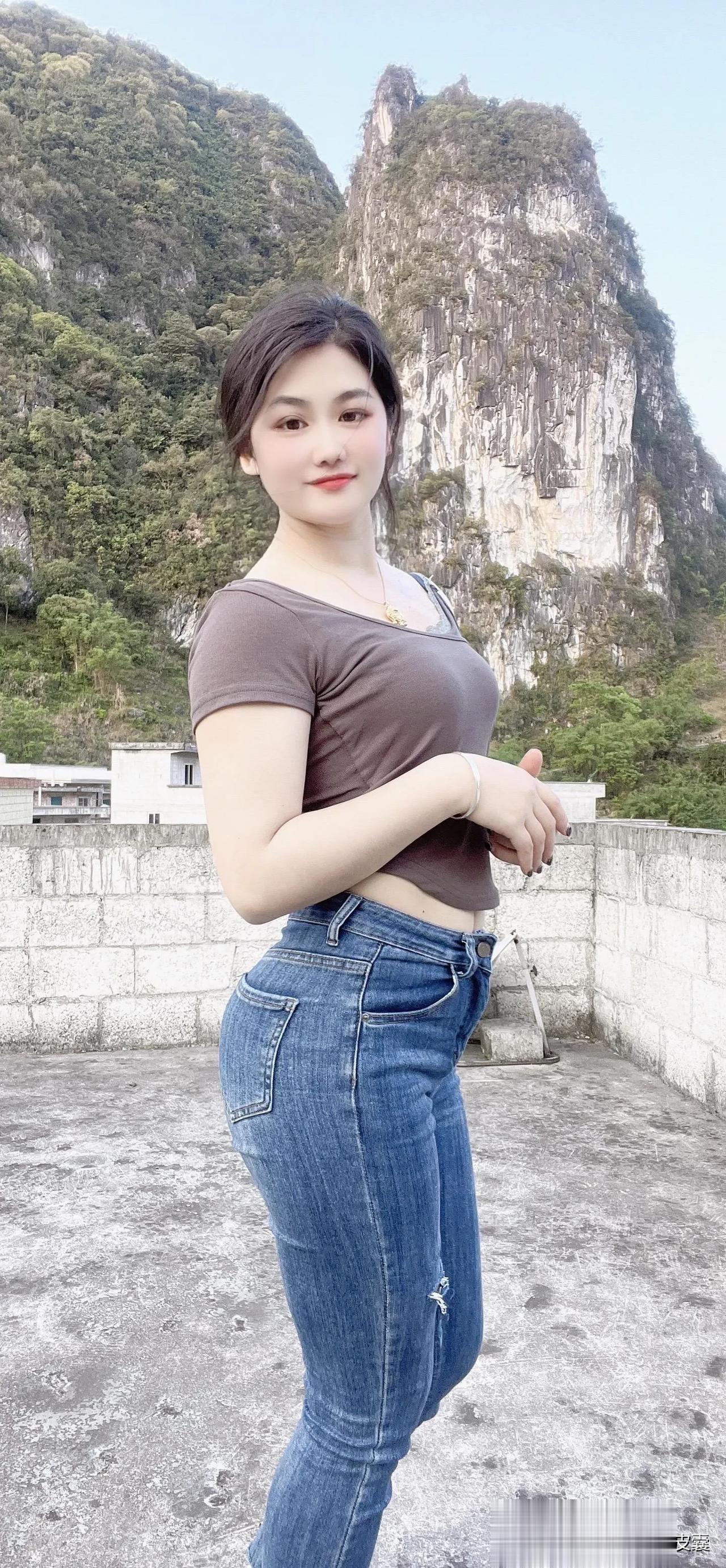 这位调皮的姑娘,穿着一条牛仔裤,在山里的院子拍照,看她微笑的表情