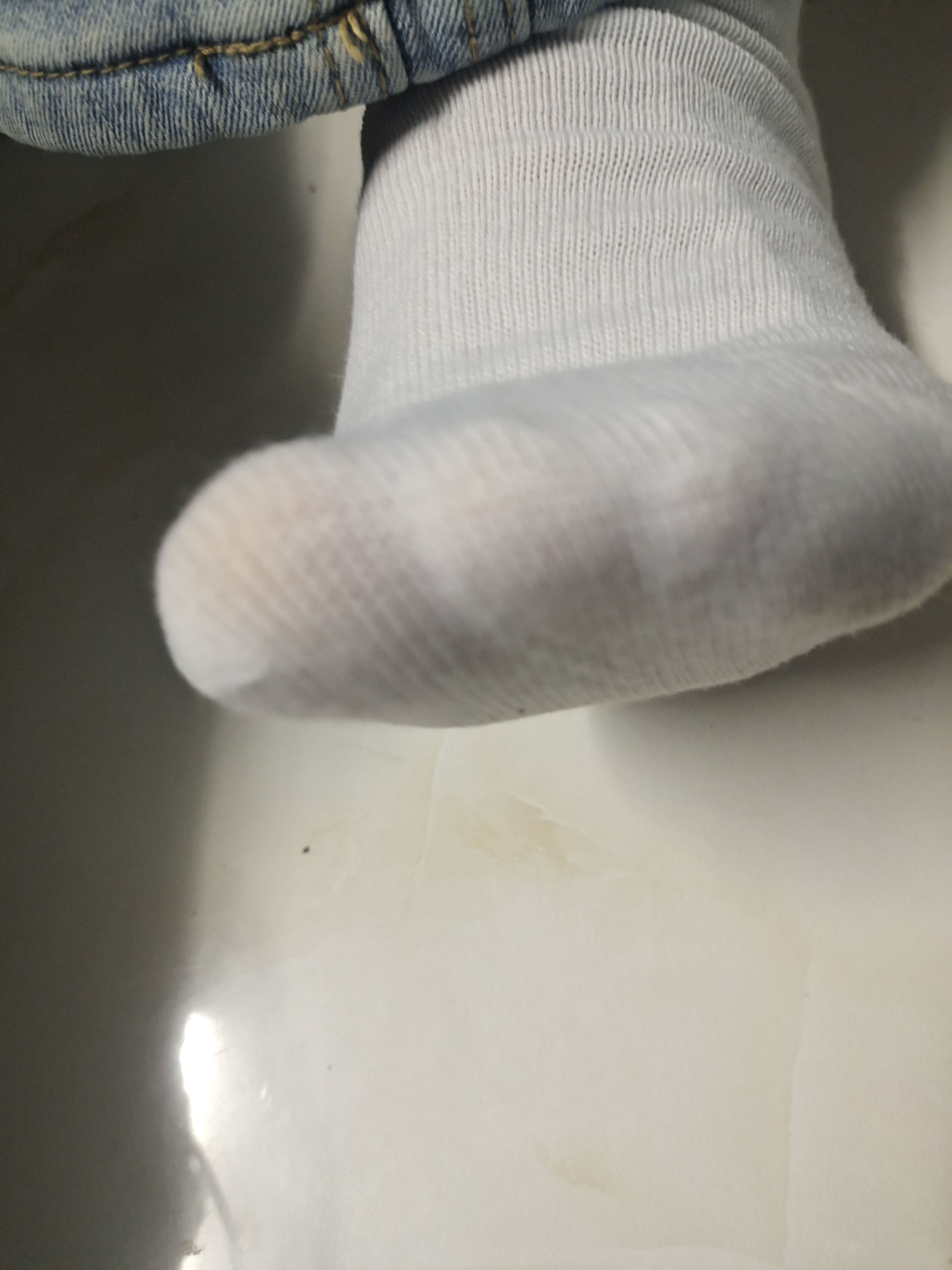 一只脚,一只破洞的袜子,露出了下面的肌肤.