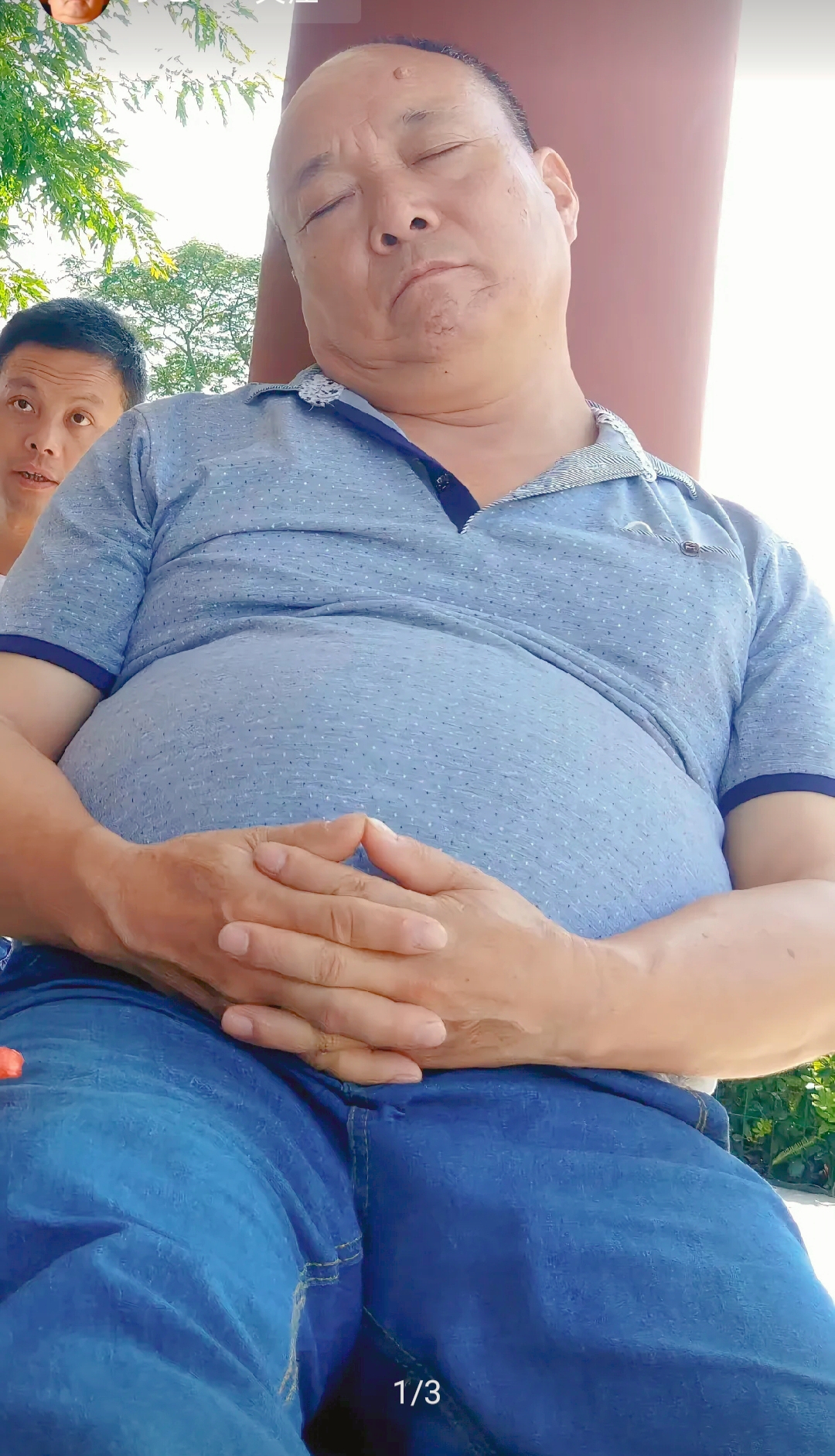 这个男子,穿着蓝色的上衣和牛仔裤,双手放在肚子上,正在安静地睡觉