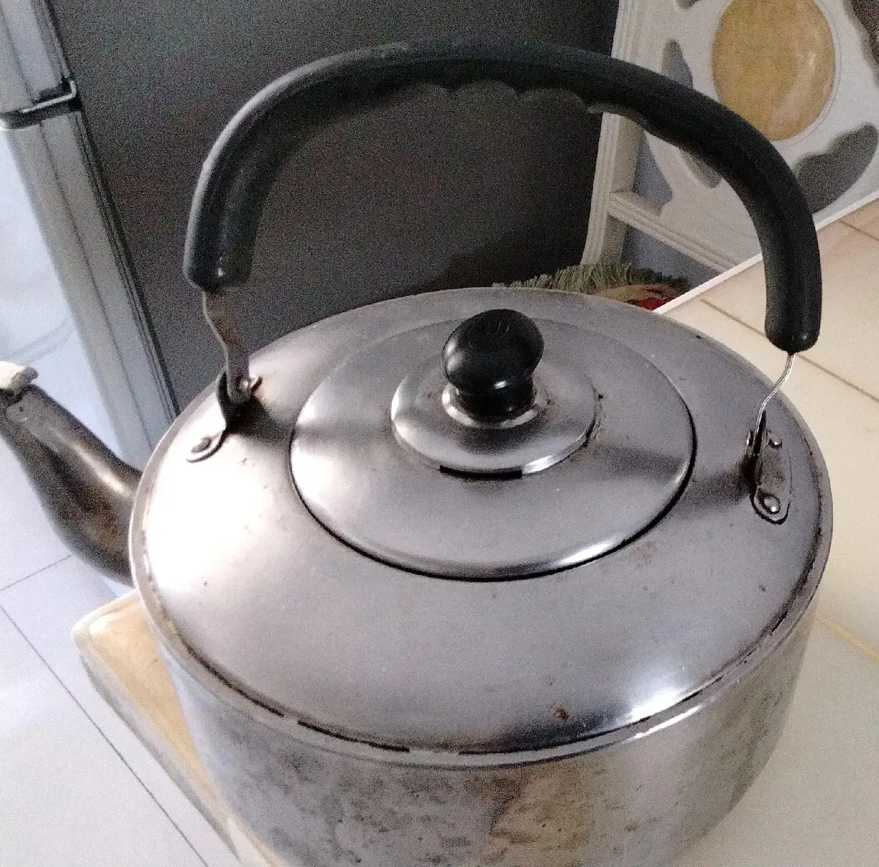 岁月像把无形刻刀,用了十余年的铝壶在昨日烧水时,如同垂暮老者般"