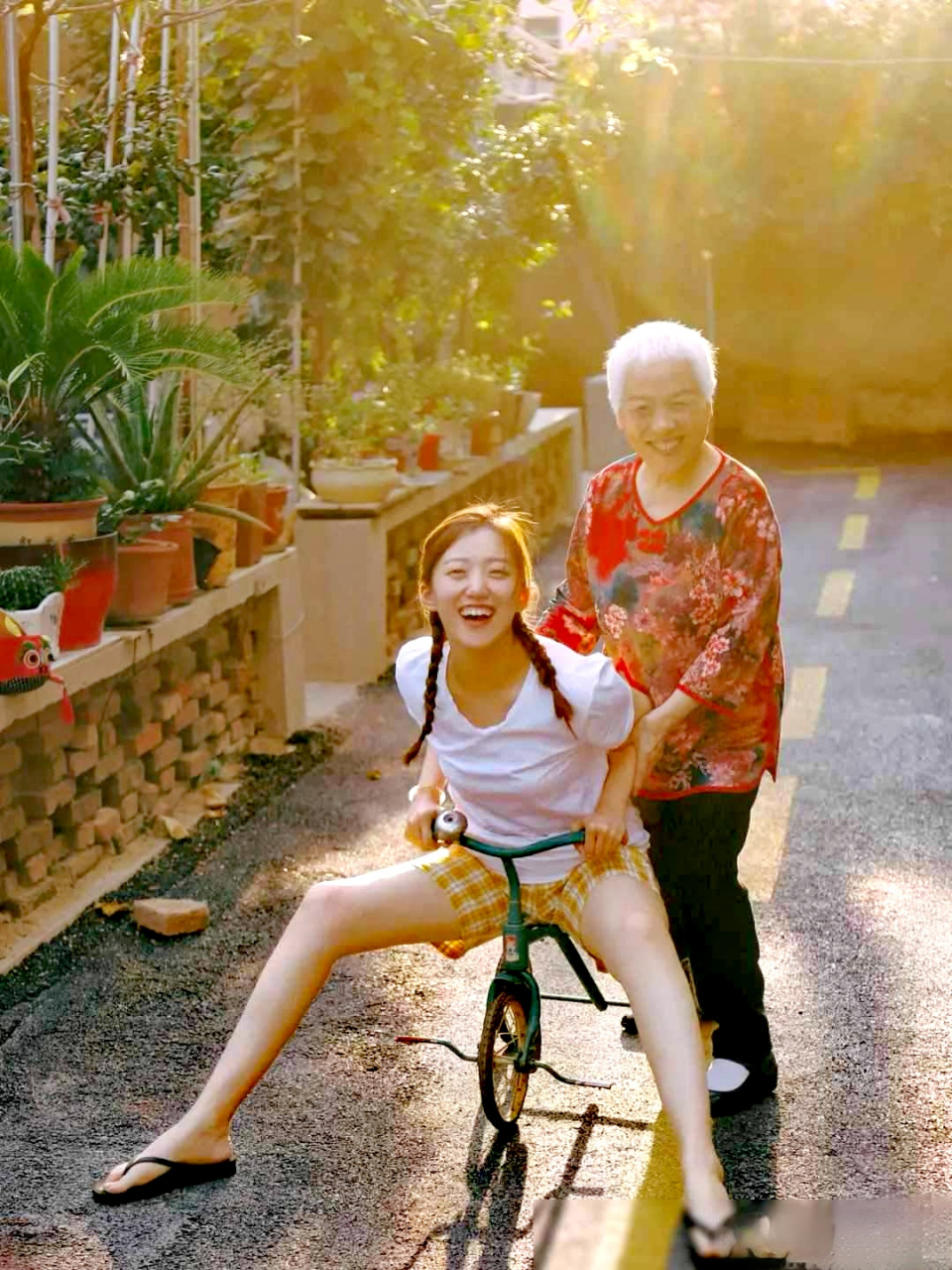 一位慈祥和蔼的老奶奶正和她活泼可爱的孙女在愉快地玩耍.