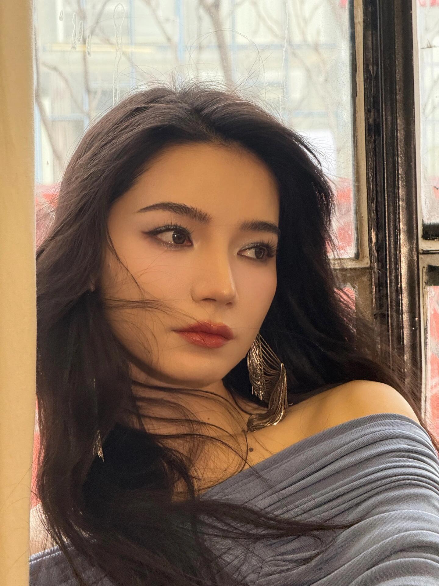 代斯长发随风轻轻舞动耳畔流光溢彩的耳环映衬出她的温婉与灵动