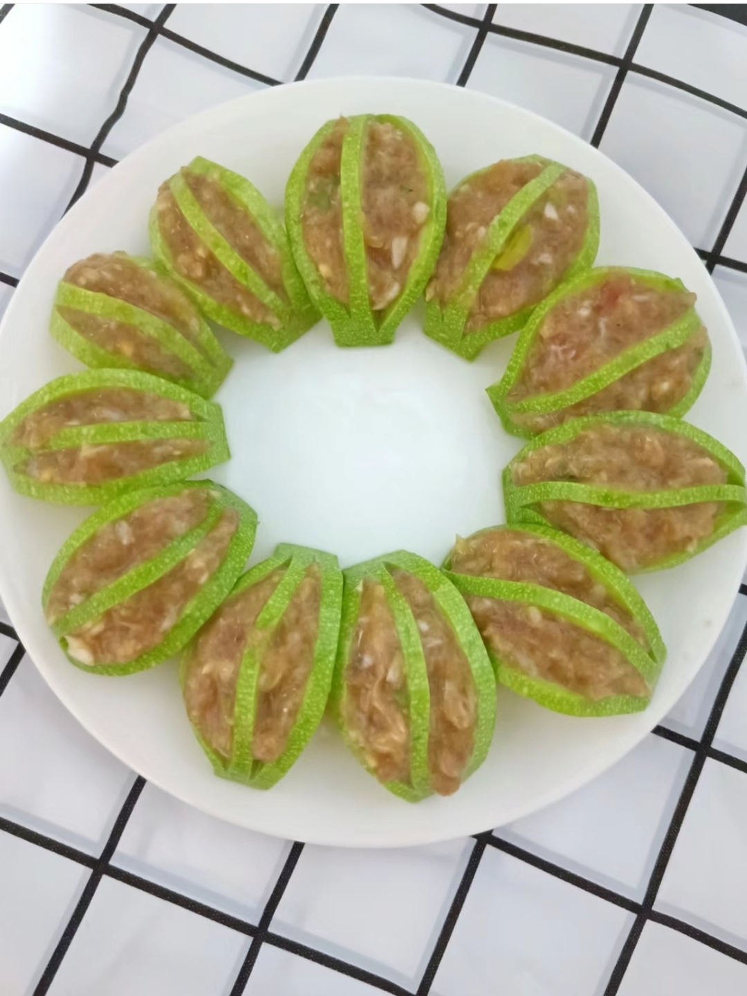 将肉馅嵌入西葫芦片中,上锅蒸熟.西葫芦清爽,肉馅鲜嫩多汁.