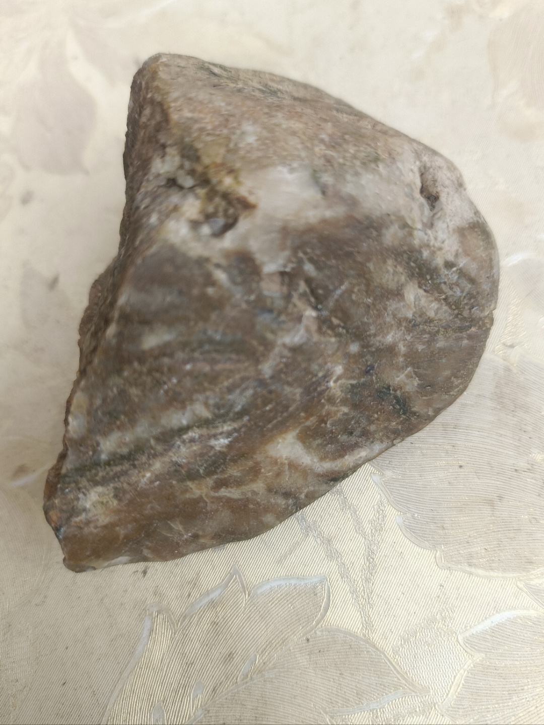 这块石头比翡翠硬,微透明,打灯透光,断面是颗粒晶体
