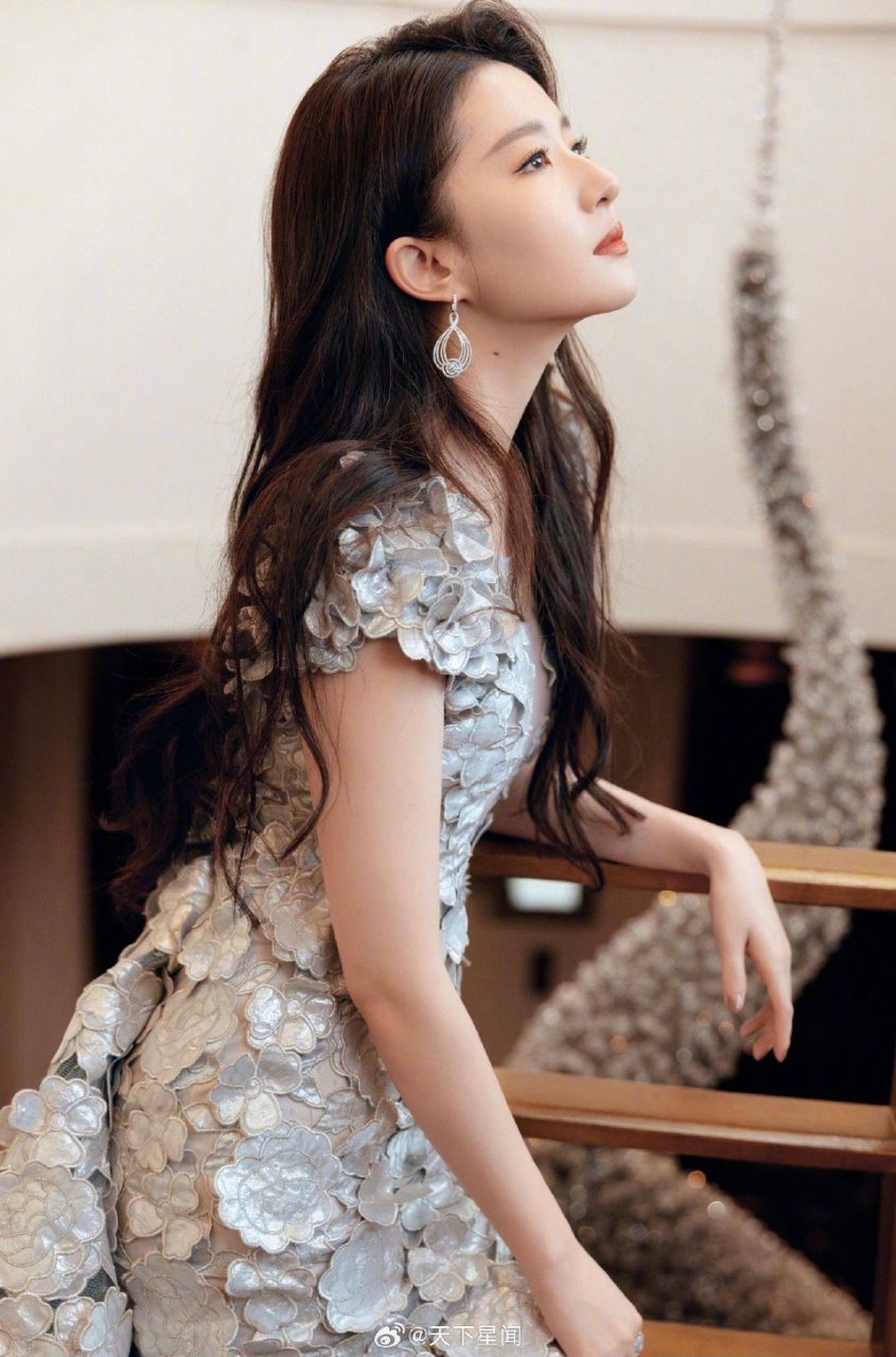 刘亦菲身着红色长裙,头戴花环,坐在那里的她,就像一幅美丽的油画.