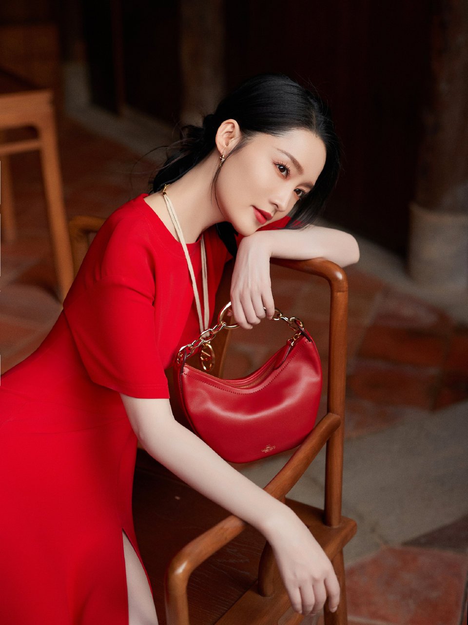 李沁的红色手提包点缀着整个暗色调背景,就像生活中的一抹亮色,提醒