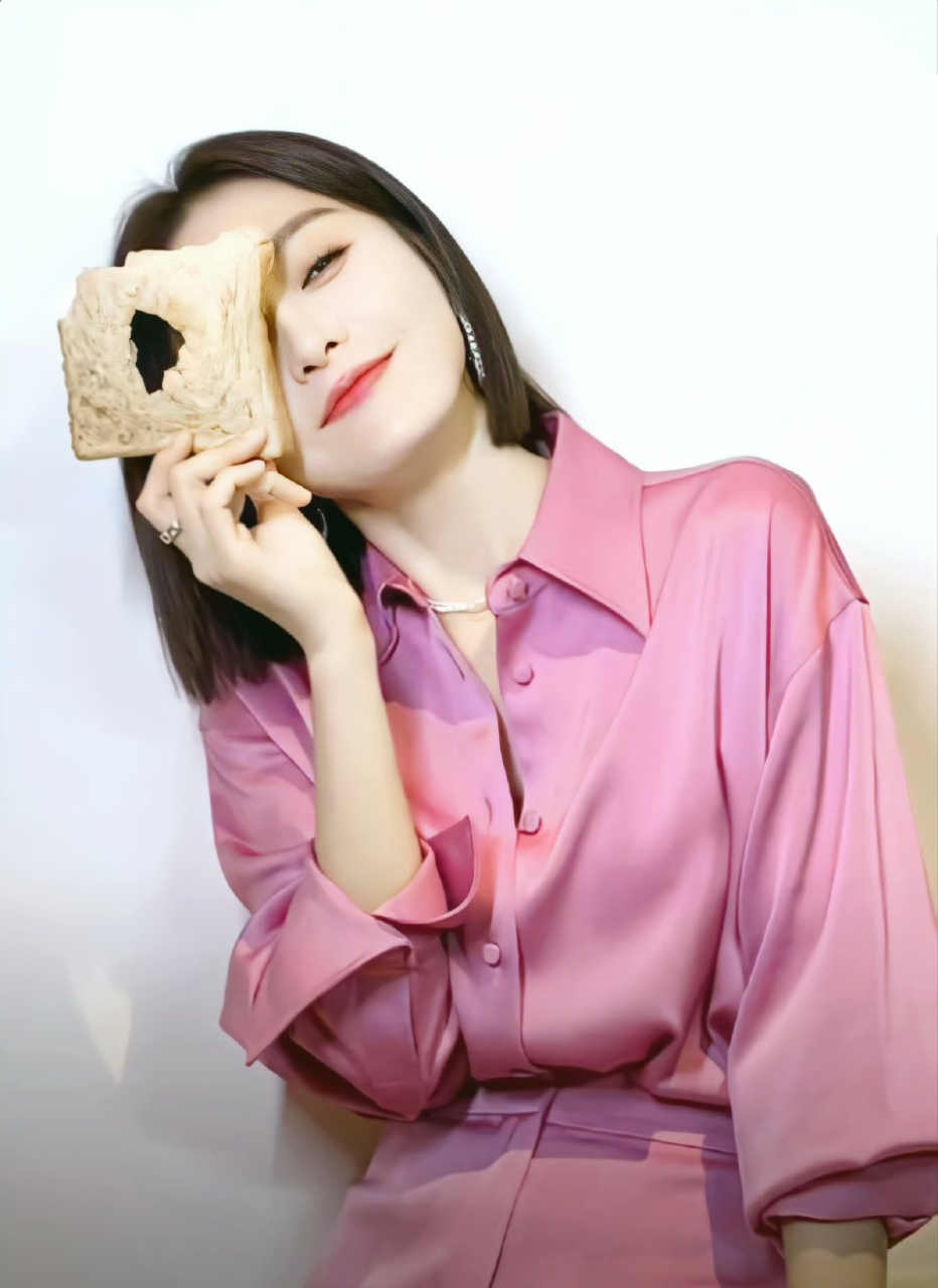 秦岚身着粉色衬衣边吃面包边摆拍,彰显出俏皮可爱的氛围感,而她的双眸