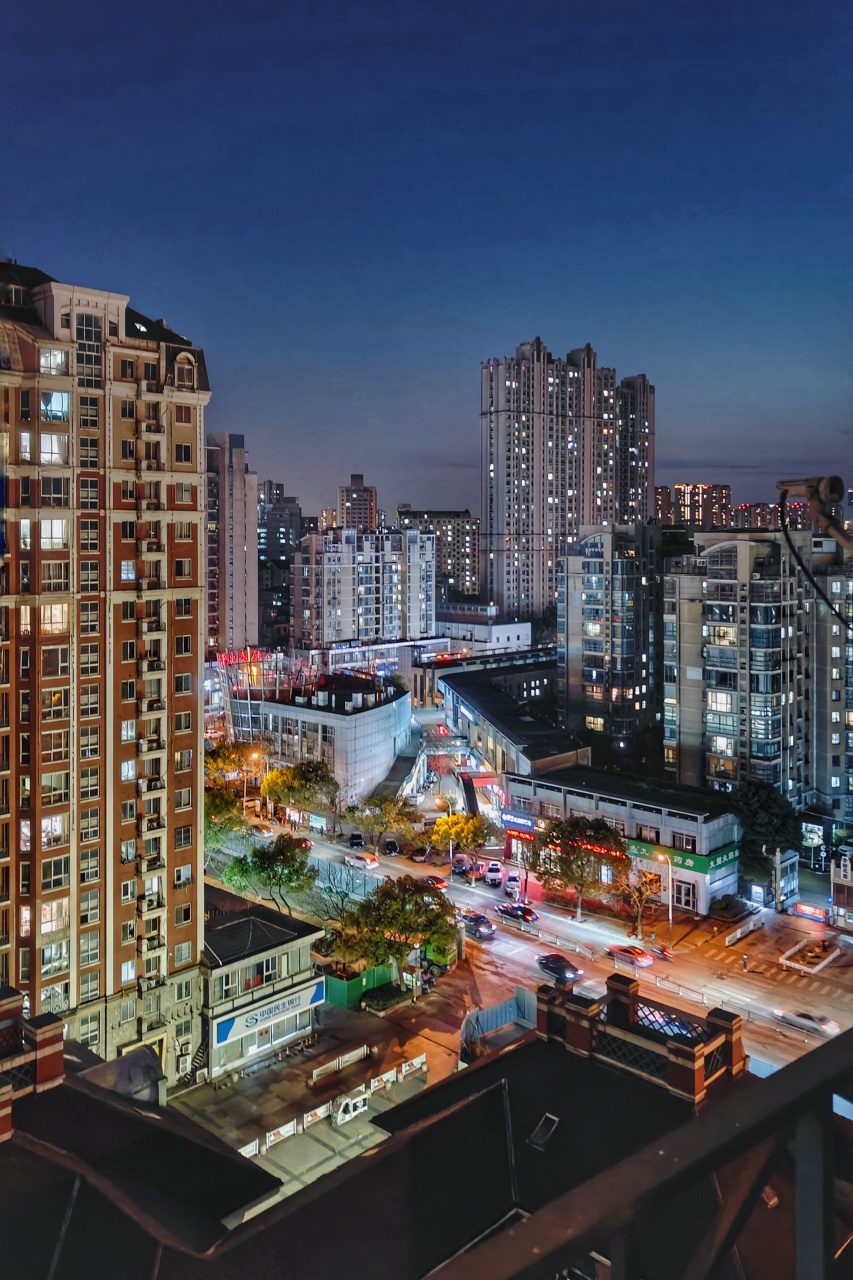 高楼大厦亮起温暖的灯火,车辆在街道上穿梭,像是流星划过夜空.