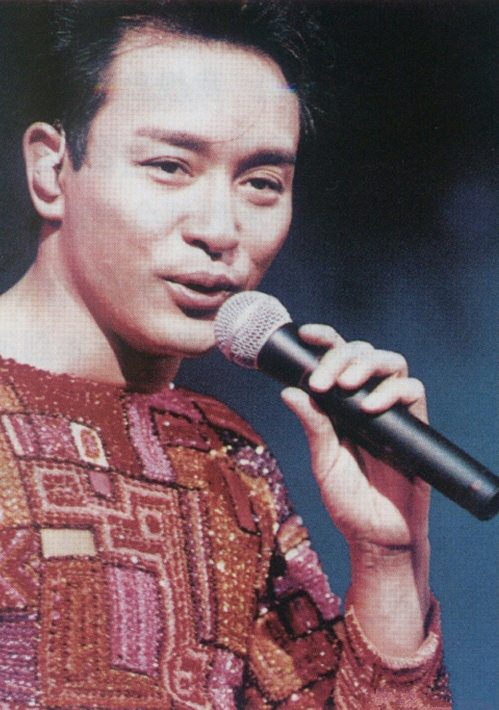 张国荣跨越九七的演唱会上,他身穿一袭红衣,站在舞台上,随着音乐翩翩