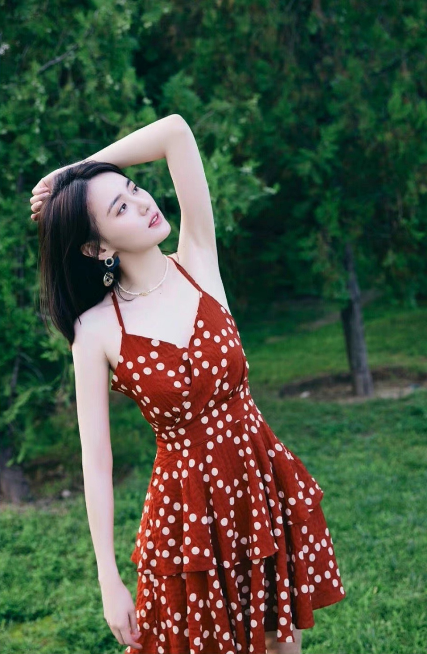 江铠同在绿意盎然的公园里,穿着红白波点裙,优雅地摆好pose,准备拍下