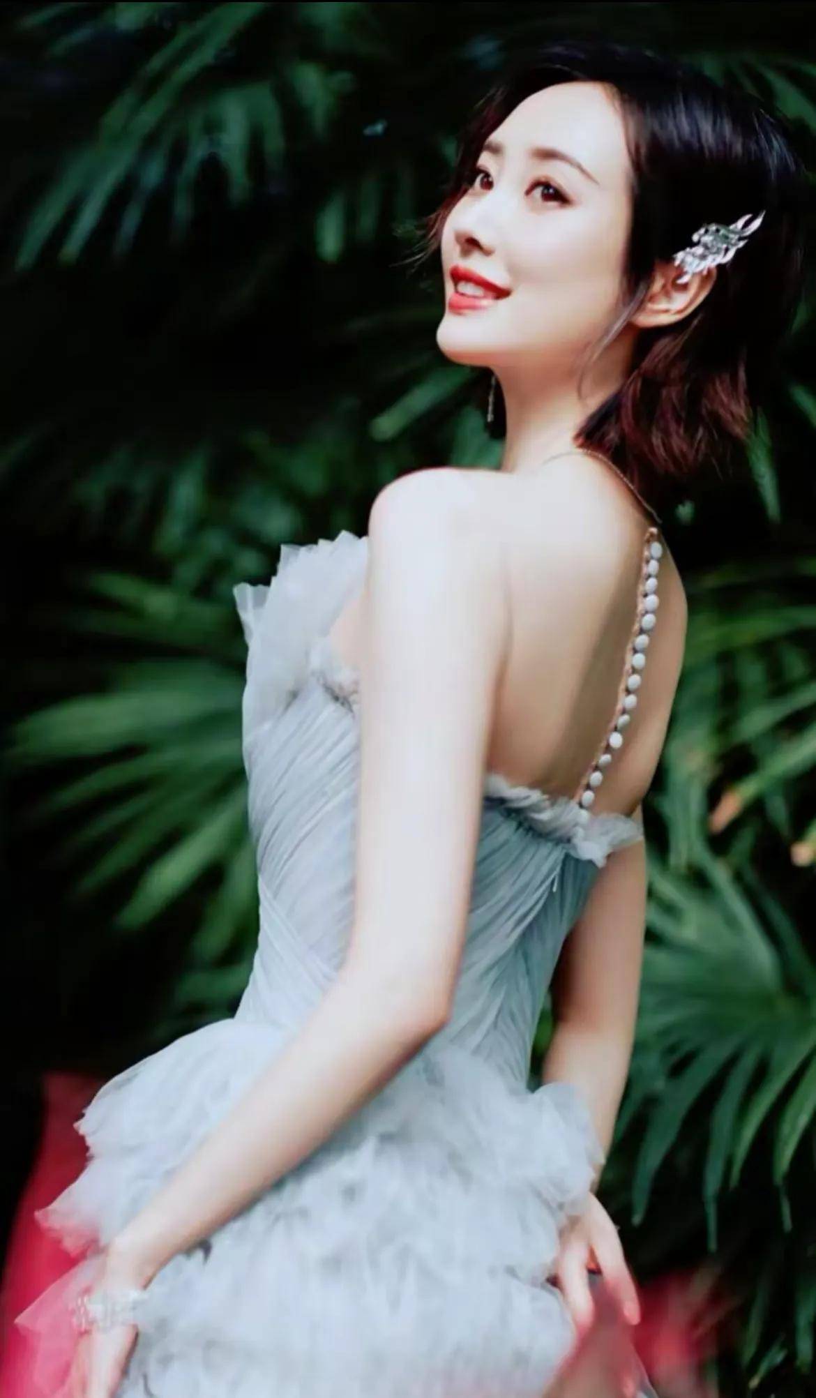 "李纯穿着梦幻的纱裙,站在绿意盎然的背景前,宛如森林中的仙女