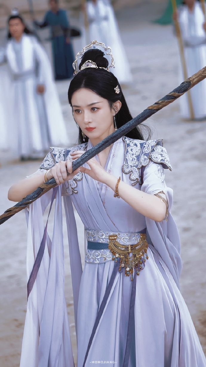 赵丽颖英姿飒爽, 手持长棍, 眼神坚定, 仿佛从古风画卷中走出的侠女