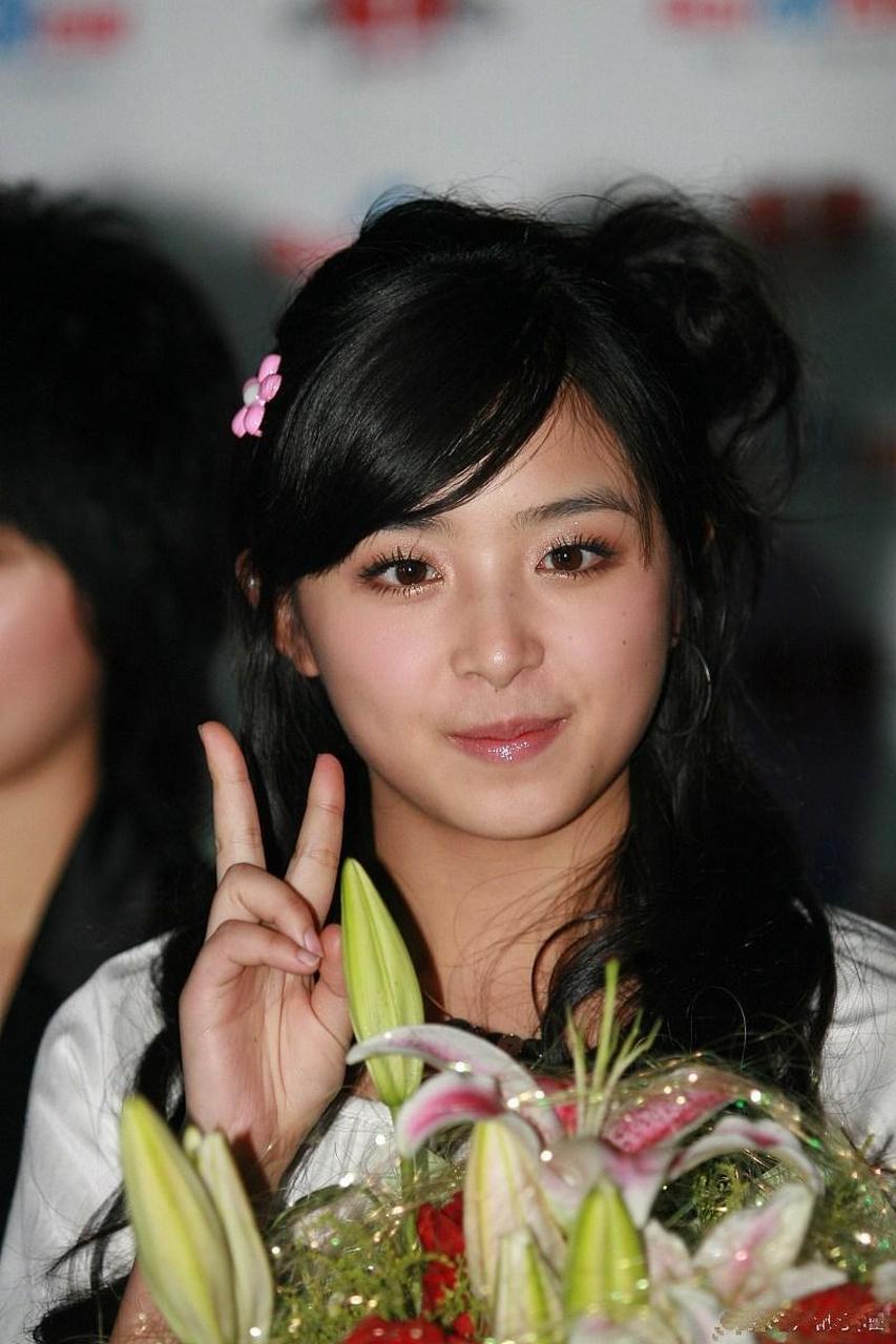 张含韵手比 peace,拿着花笑得真好看～在阳光下,笑容与花儿交相辉映