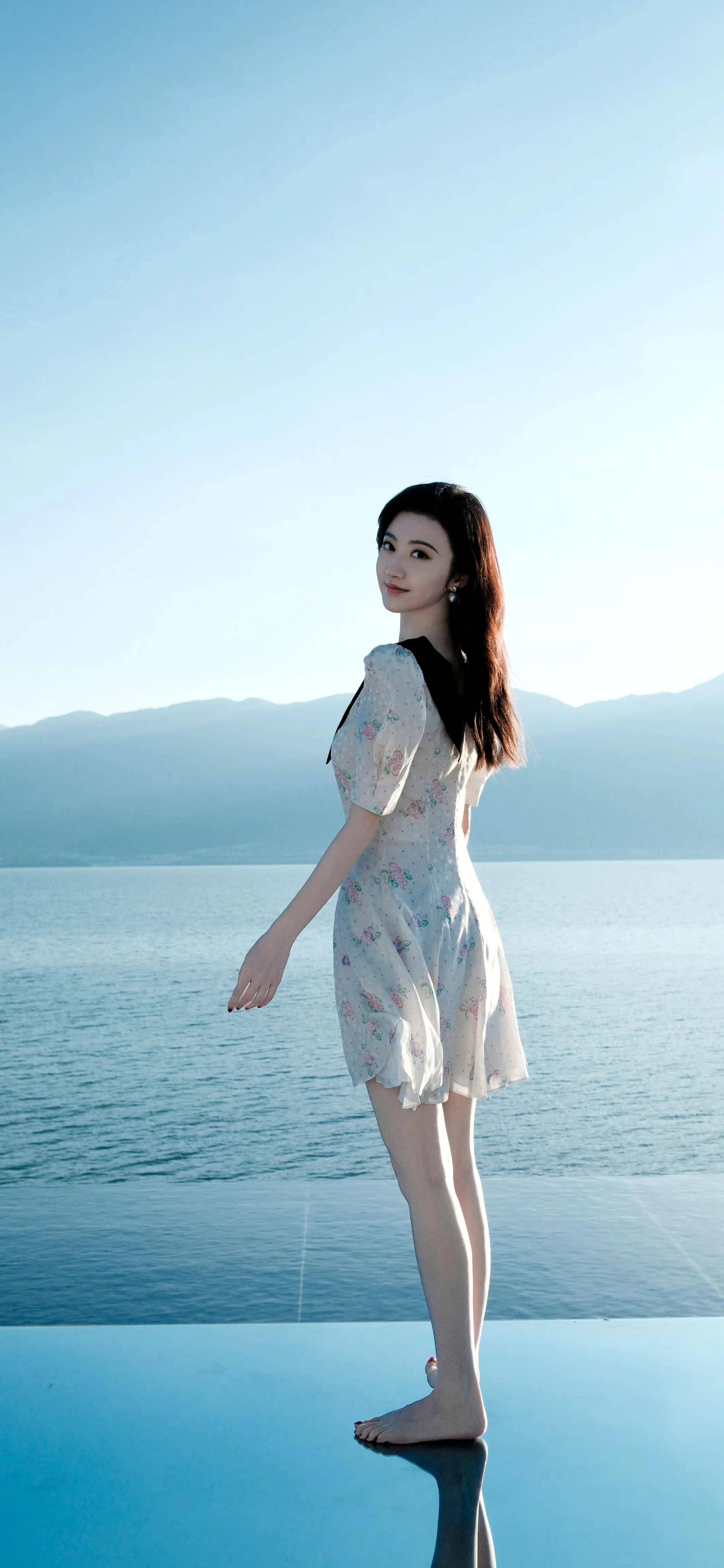 "景甜站在无边泳池边缘,远处是宁静的海和山,美得像一幅画