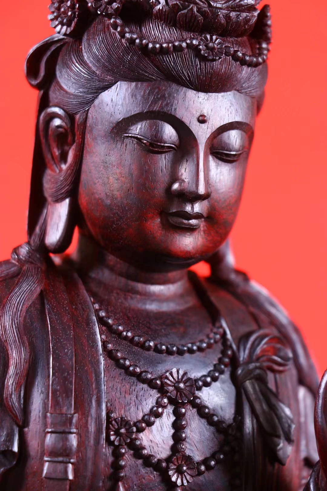 这是一尊小叶紫檀《持珠观音佛像》,是观音菩萨手持念珠的一种常见