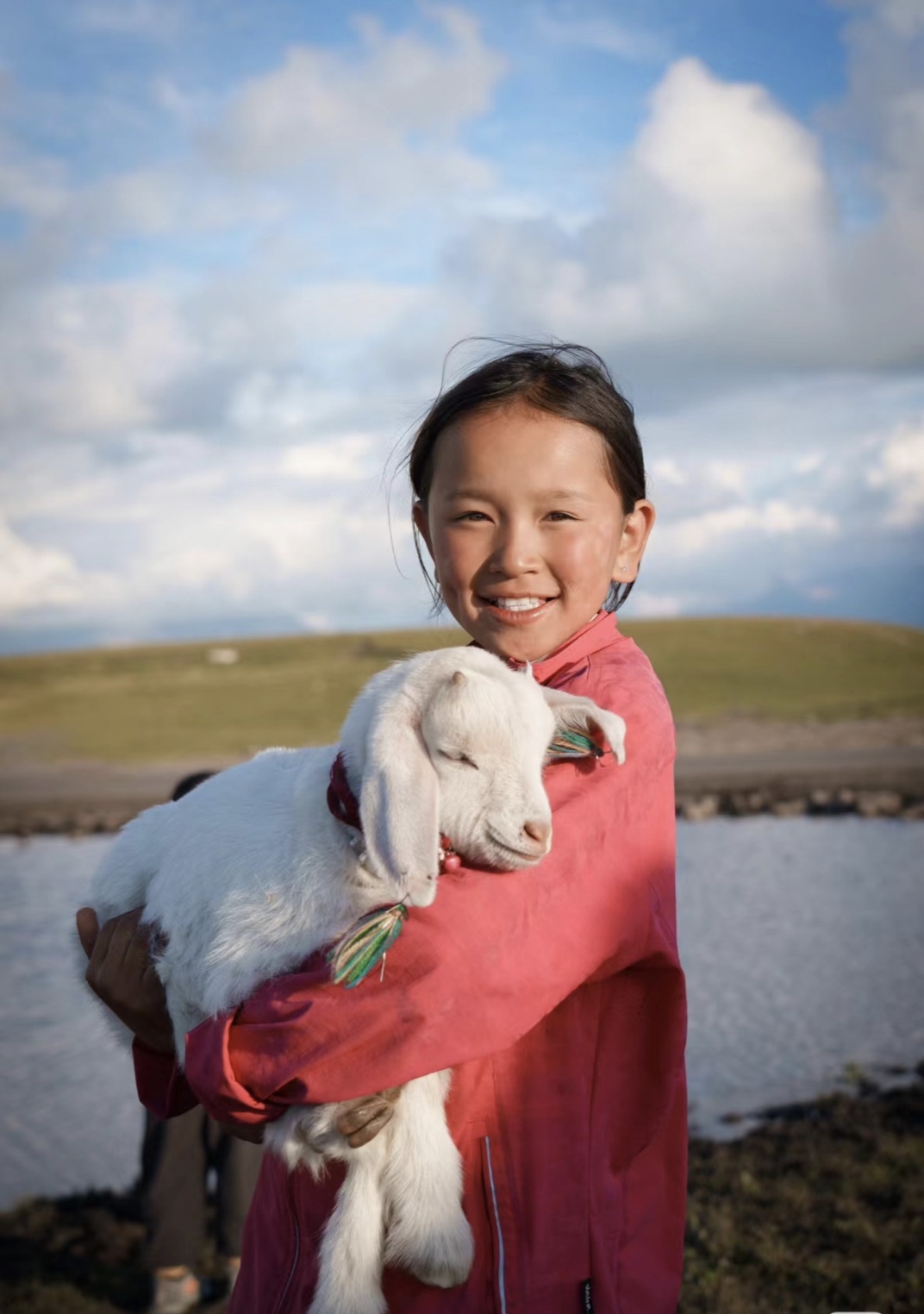 一位小姑娘身着鲜艳的红衣,笑容比阳光还灿烂