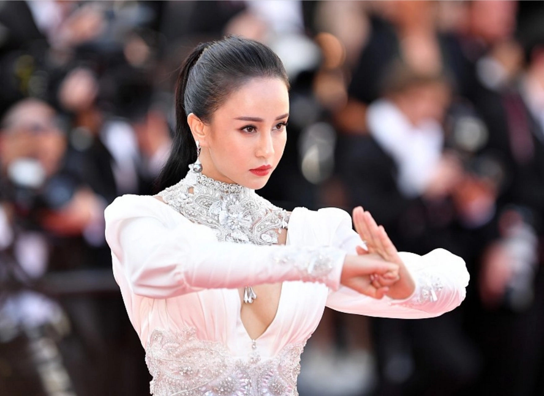 母其弥雅身穿白色长裙,领口采用深v设计,扎马尾配红唇显得格外干练