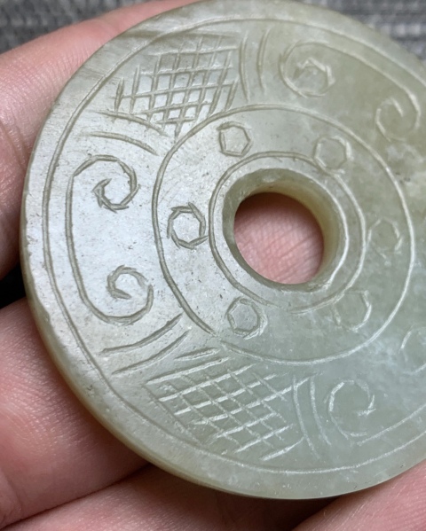 此卷云纹玉壁就图看,材质为和田料子,色青白有棉,开门老带工璧造型.