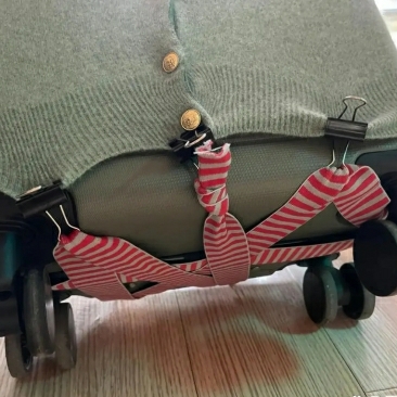 出差路上,旅行箱用别致的红绳绕着,毛衣的形状披在行李箱上,与众不同