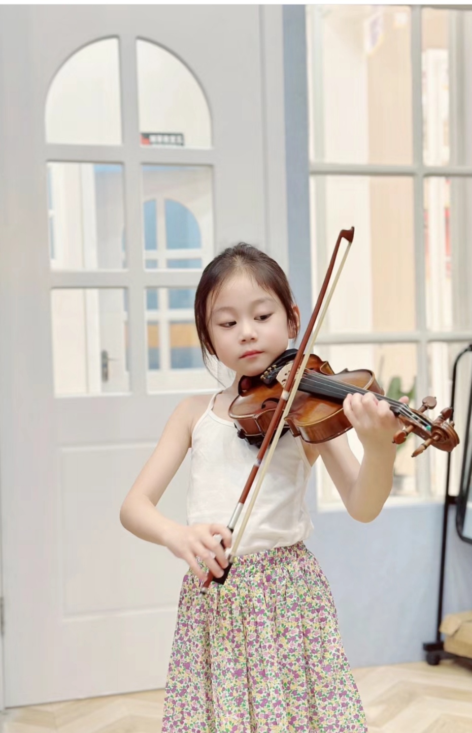 小提琴女孩,音乐中的花仙子 看这位女孩,她身着白色背心与花卉裙,仿佛