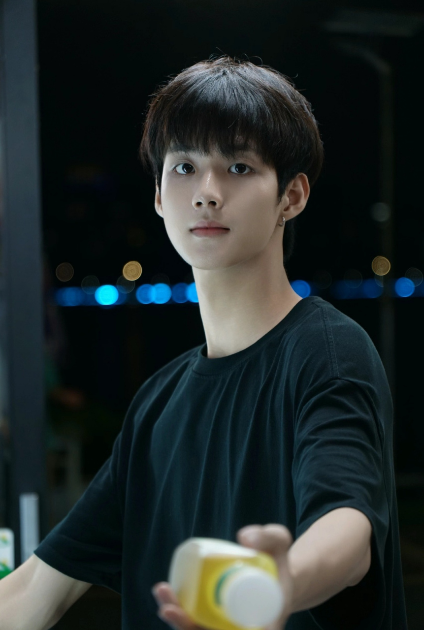 19岁的大一男生,黑色t恤,在夜色中显得皮肤更加白净,打着耳钉,时尚不