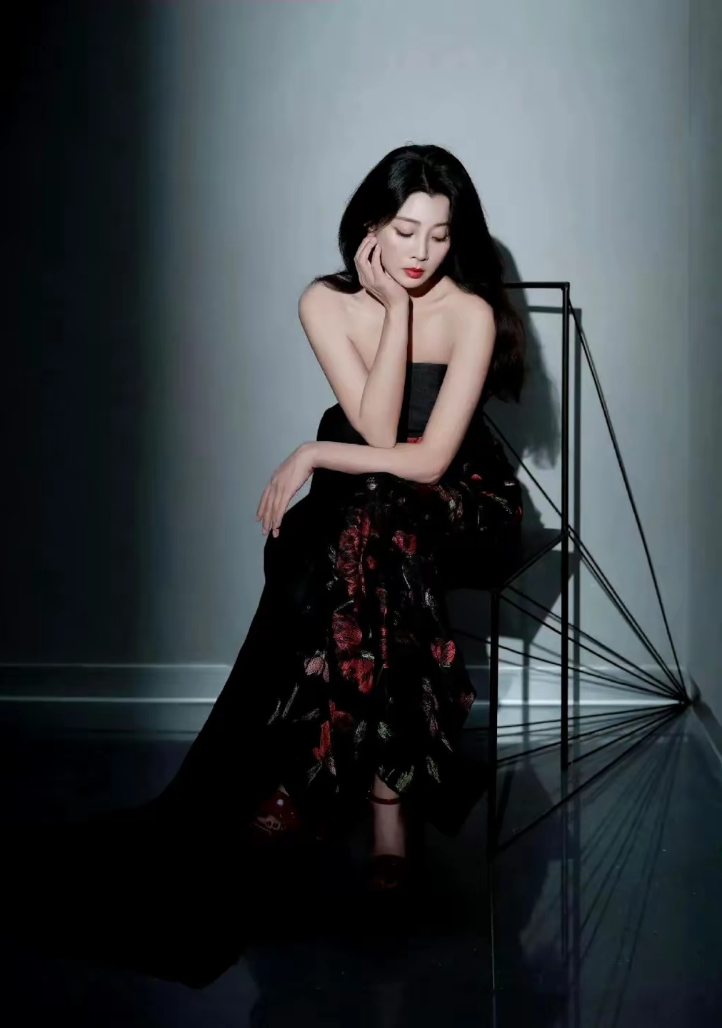 殷桃,一袭红黑拼色抹胸礼服,优雅地坐在椅子上,性感美艳,透露出一种