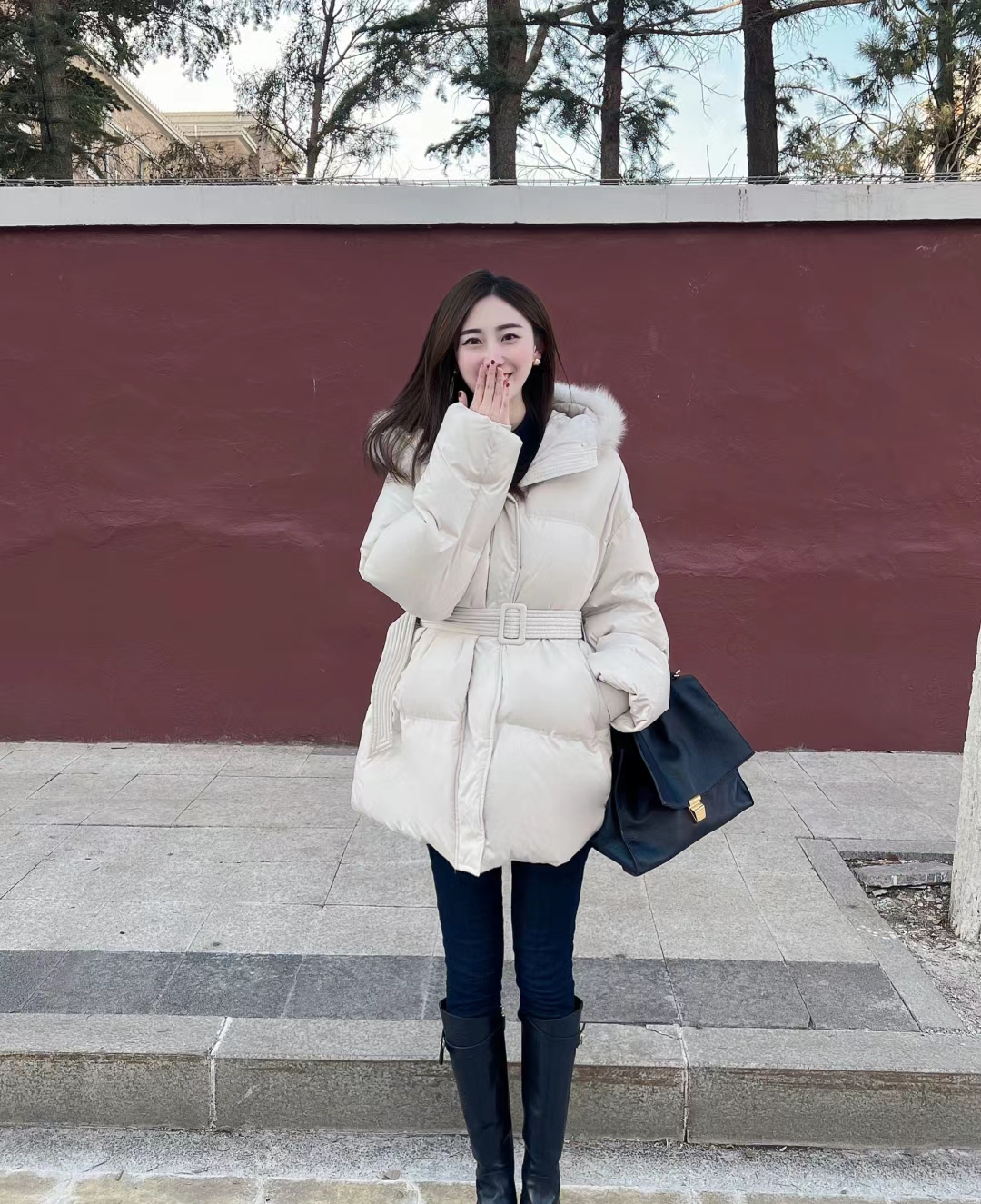身穿白色羽绒服,黑色裤子,还带着黑色包包,真的是太有范儿了!
