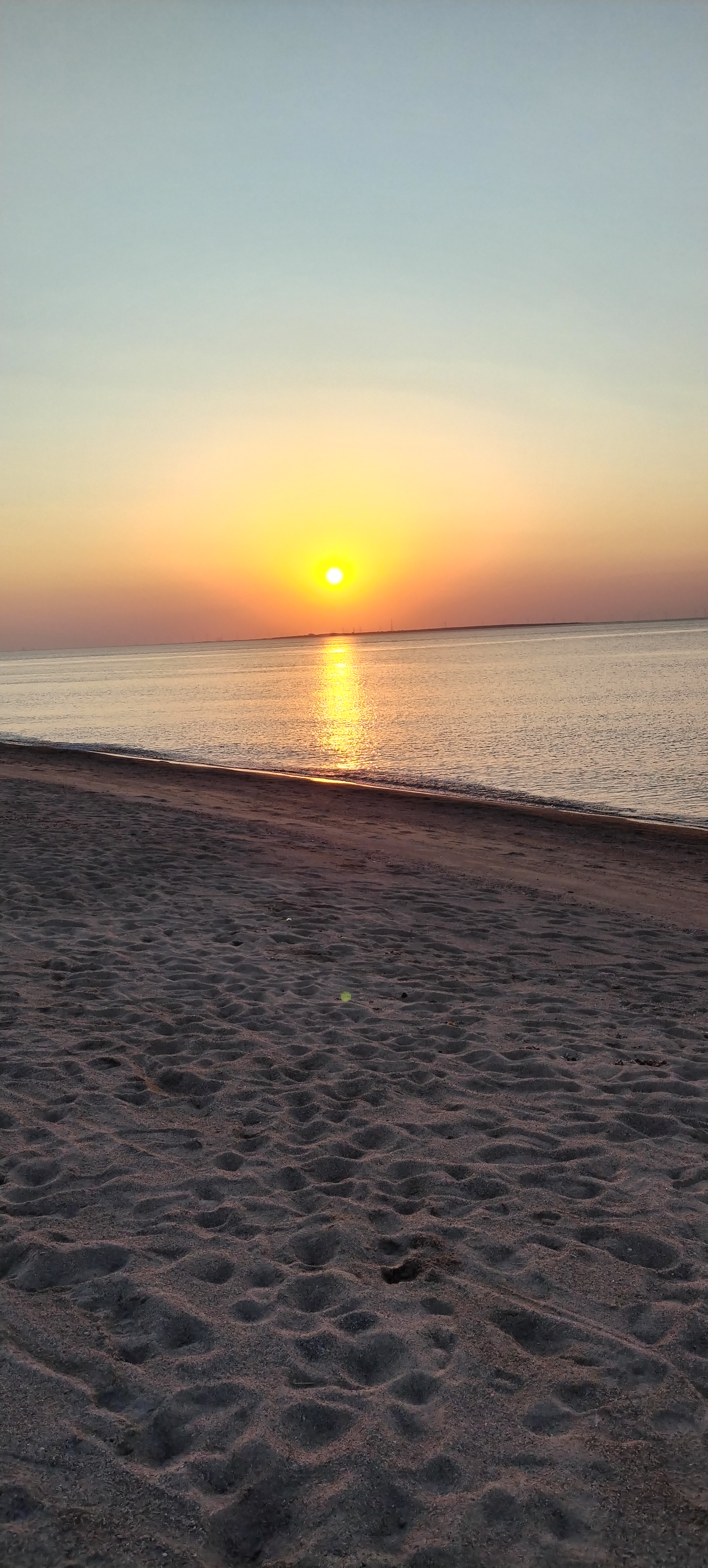 海面平静如镜,倒映着夕阳的余晖,仿佛整个世界都被染上了金色.