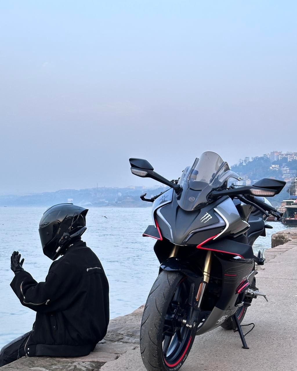 一旁停着的黑色与红色相间的摩托车,是都市生活的印记,也是冒险旅程的