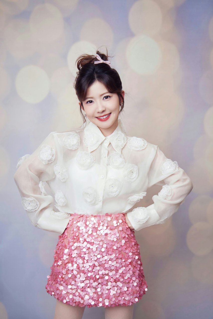 赖美云, 蹲姿俏皮, 笑容甜美, 背景梦幻, 粉嫩搭配, 时尚感十足.