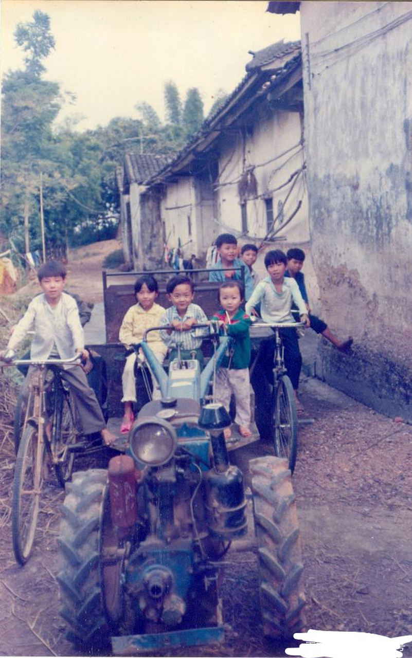 一张生活老照片,80年代的广西南宁,那时候的农村里面一群小孩子在拖拉